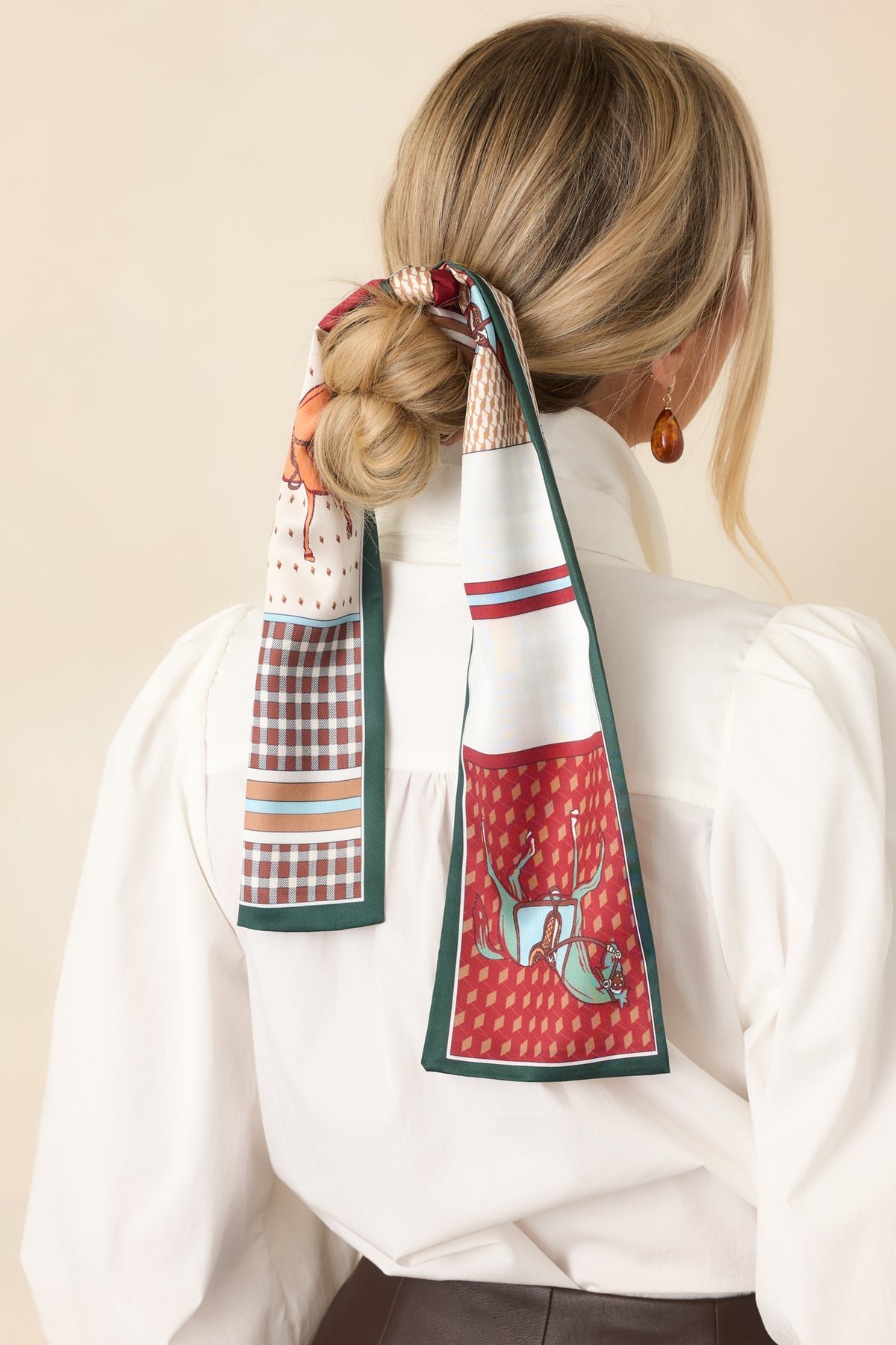 Multicolor scarf combining equestrian motifs and mixed patterns with contrasting forest green trim.