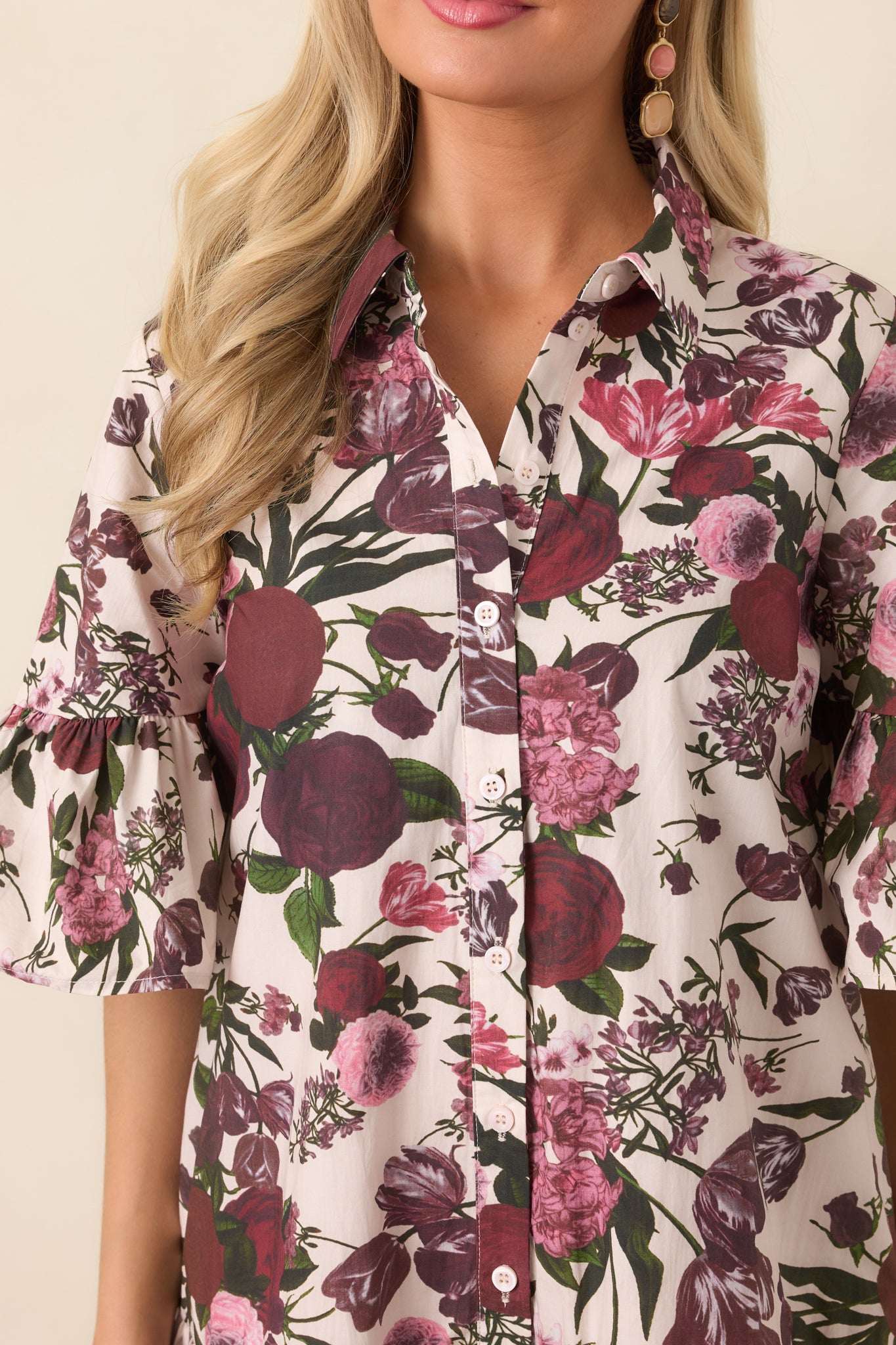 Close-up of the 100% cotton fabric highlighting the rich multicolor floral print, polished collar, and button-front detailing.