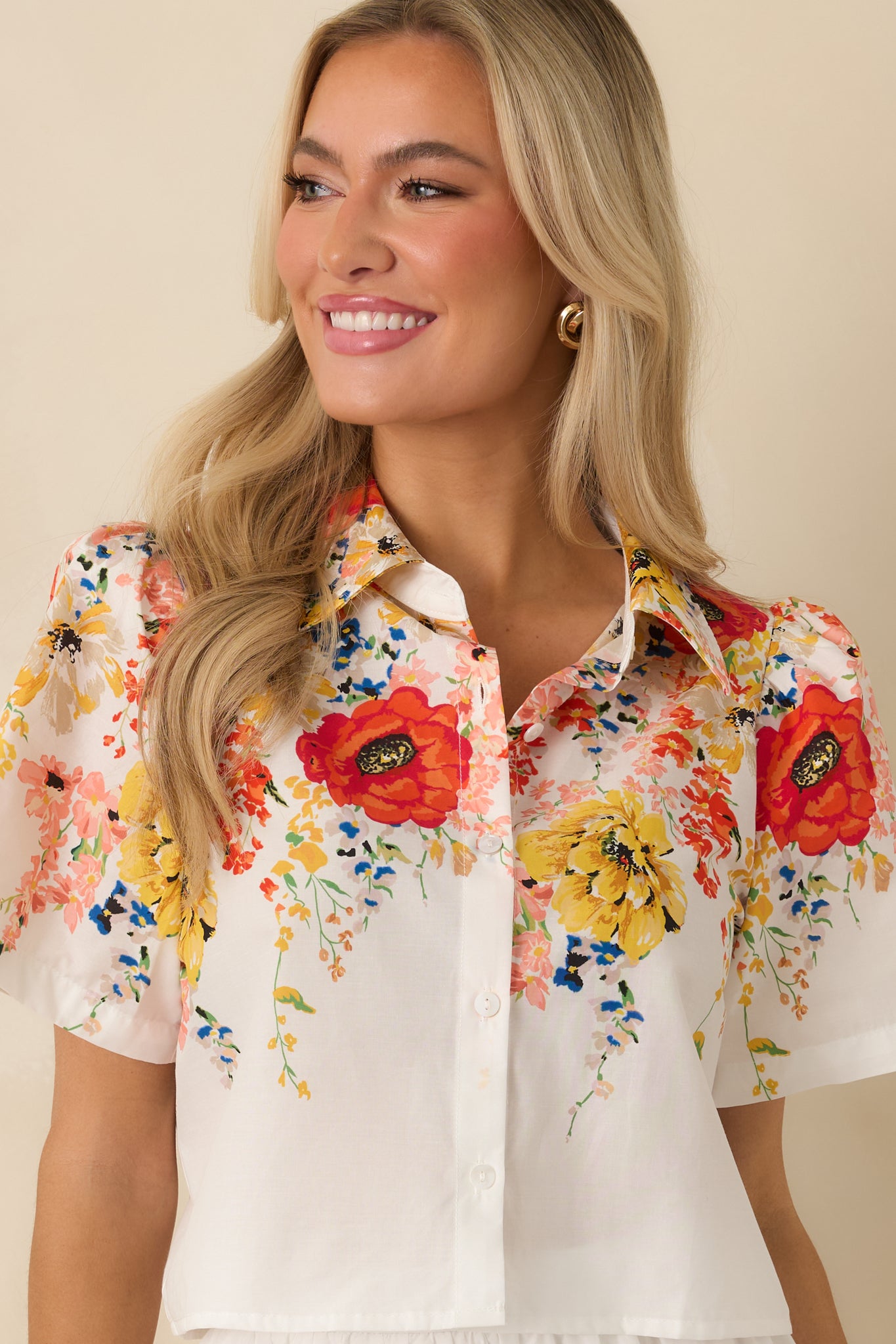 Close-up of the multicolor floral print on the white cotton fabric with visible button-down detailing.