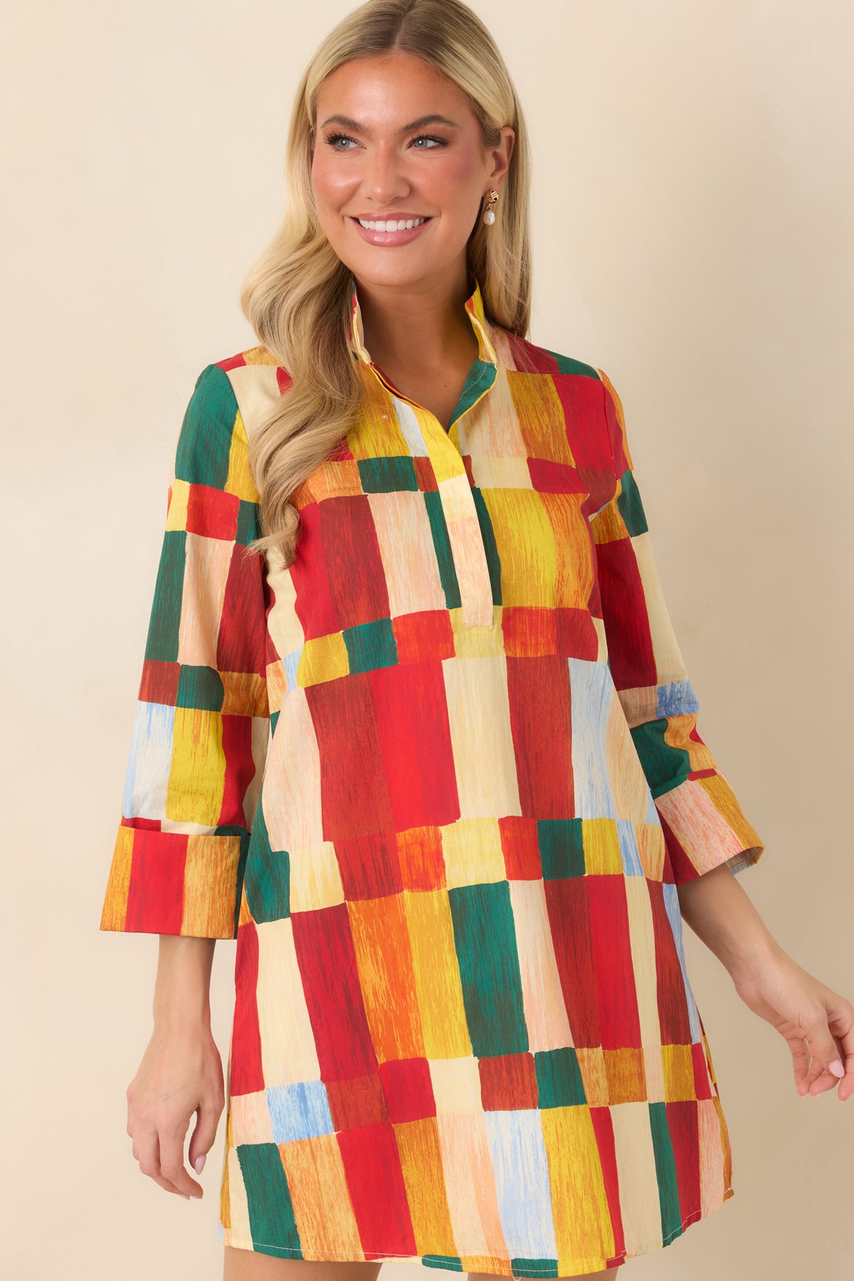 Multicolor geometric mini dress featuring a concealed button placket, structured standing collar, and three-quarter sleeves with wide cuffs.