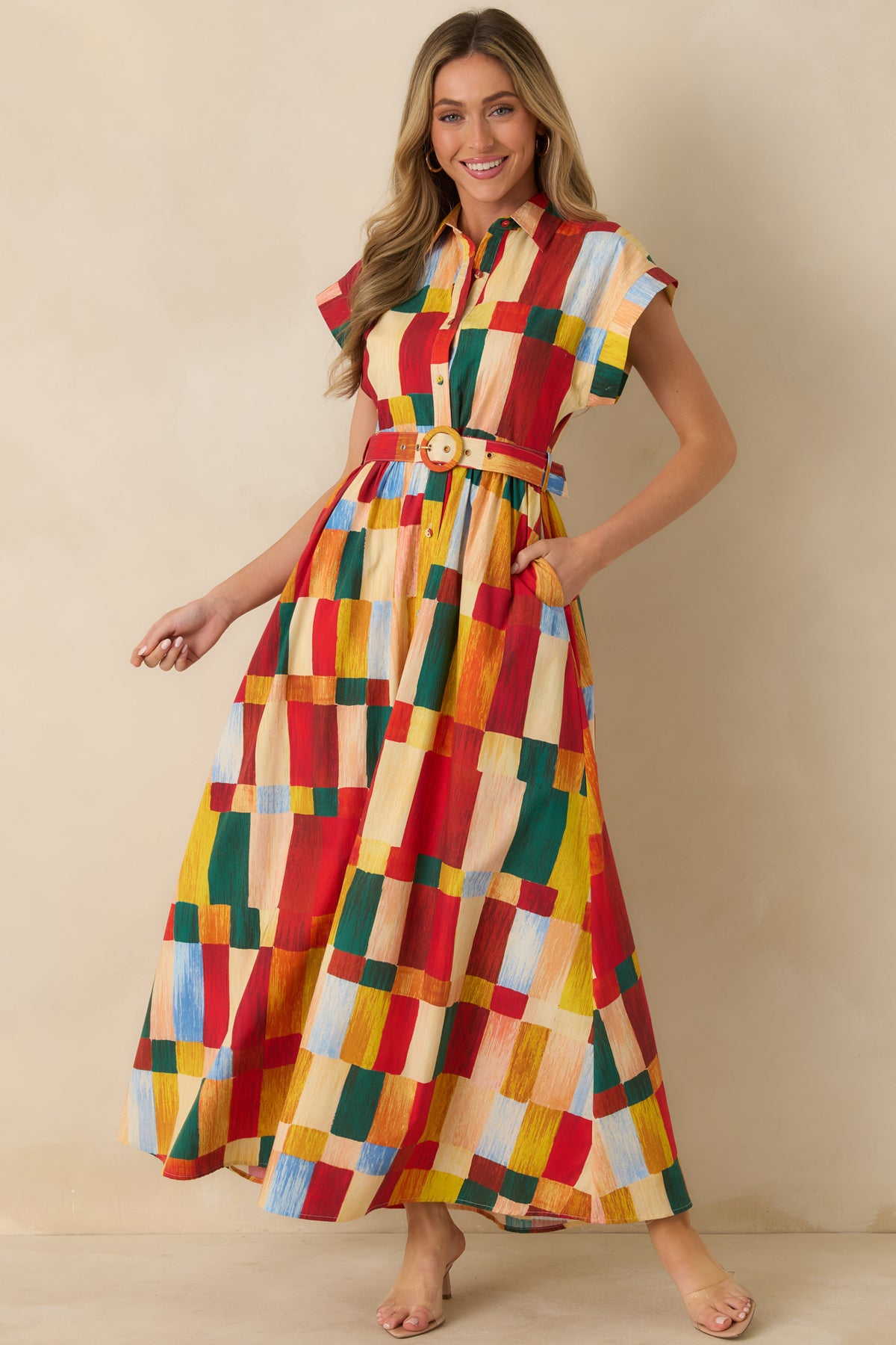 Multicolor geometric print maxi shirt dress with cap sleeves, a button front, matching buckle belt, and flowing flared skirt.