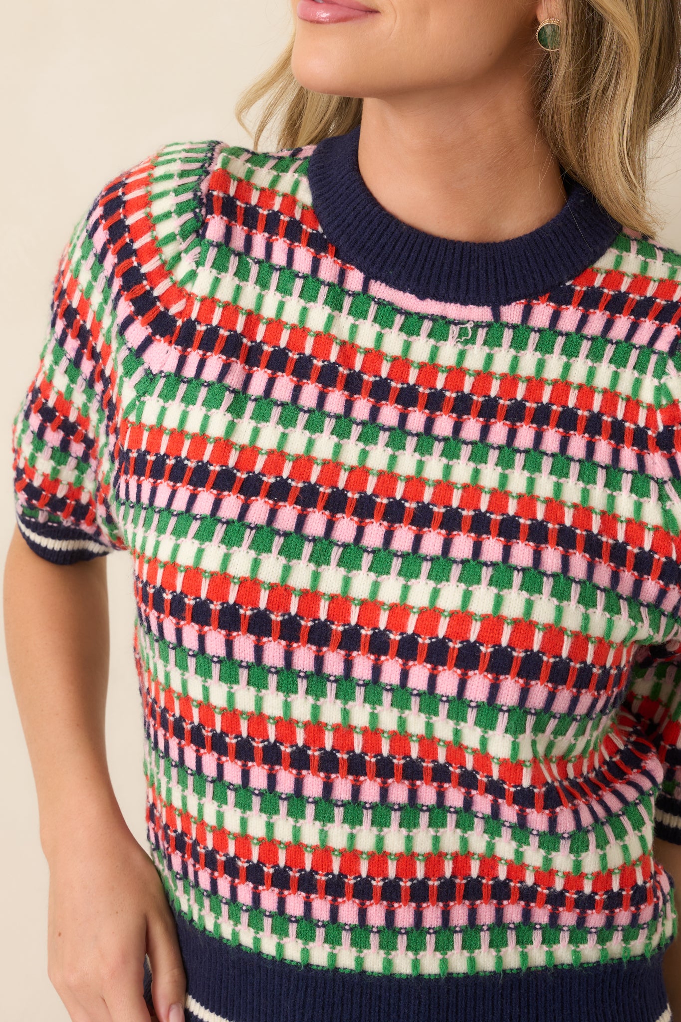Close-up of the textured multicolor knit, showcasing the navy, green, red, pink, and ivory stripe pattern and woven surface detail.