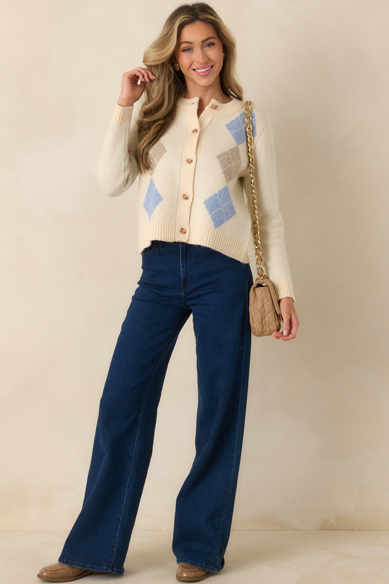 Natural multi knit cardigan with classic argyle pattern in soft blue and warm taupe, round neckline, and button-up front.