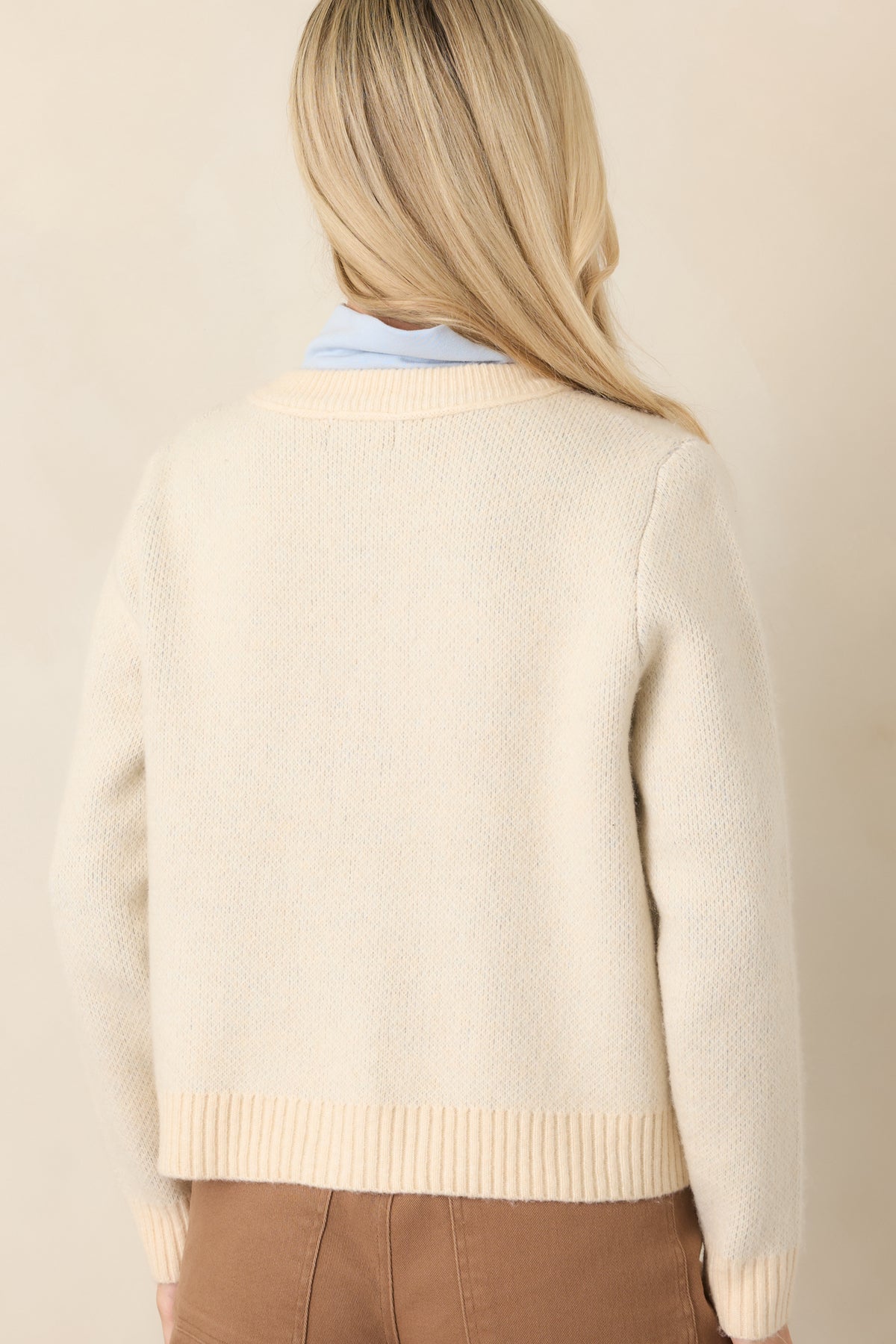 Rear view of the natural multi knit cardigan showcasing its continuous argyle pattern, long sleeves, and ribbed hem and cuffs.