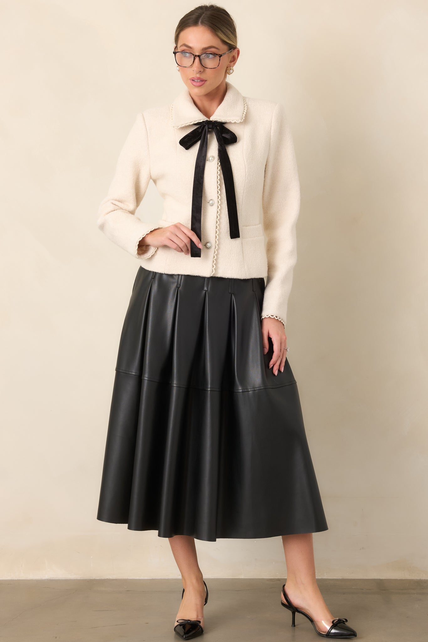 Natural wool blend jacket featuring a tailored fit, scalloped rounded collar, pearl buttons, and velvet neckline tie.