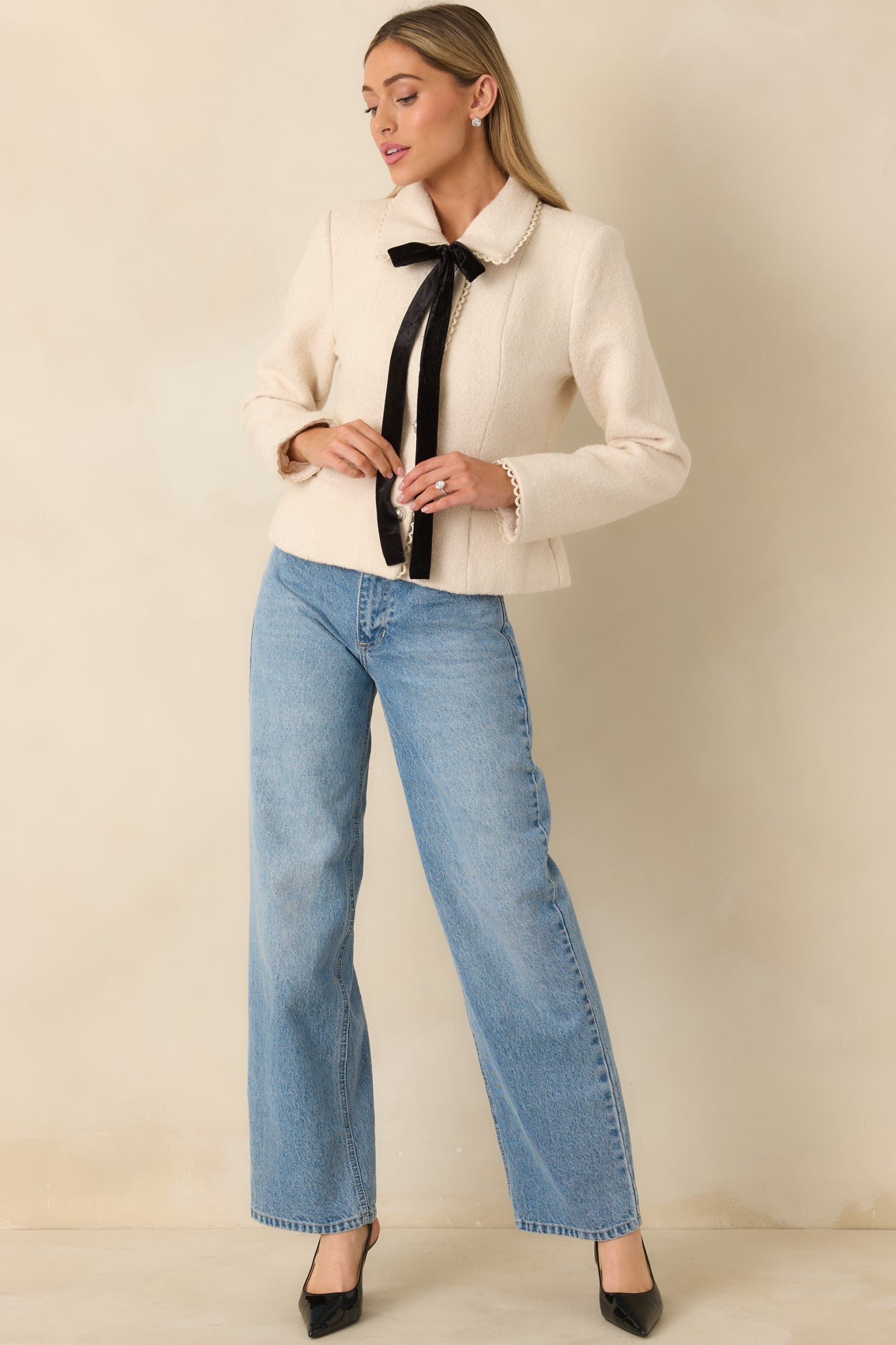 Natural-colored wool blend jacket with scalloped collar, pearl button front, velvet ribbon tie, and long sleeves.