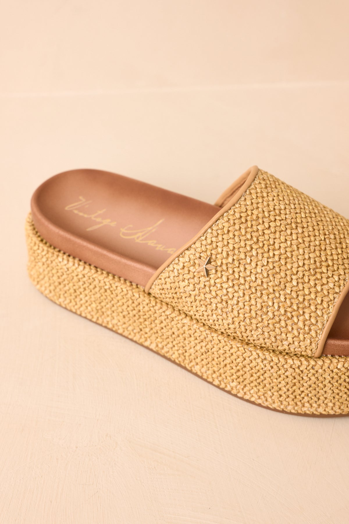 Natural woven sandals displaying the casual platform design and coordinating tan trim.
