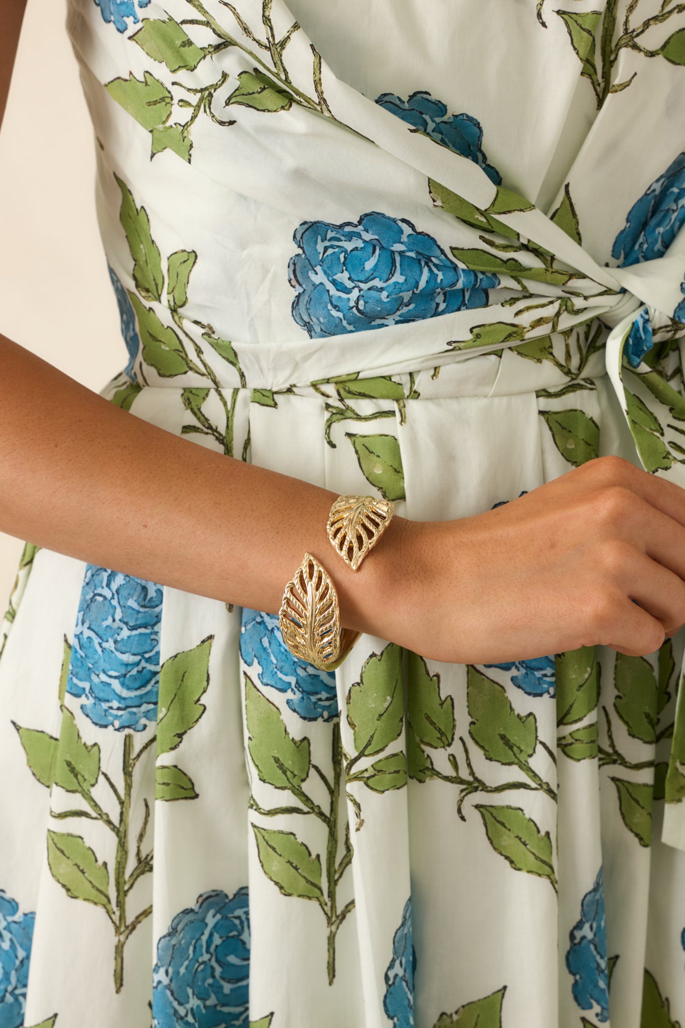 Nature-inspired gold bracelet with sculpted leaf accents and an open silhouette designed for effortless wear.