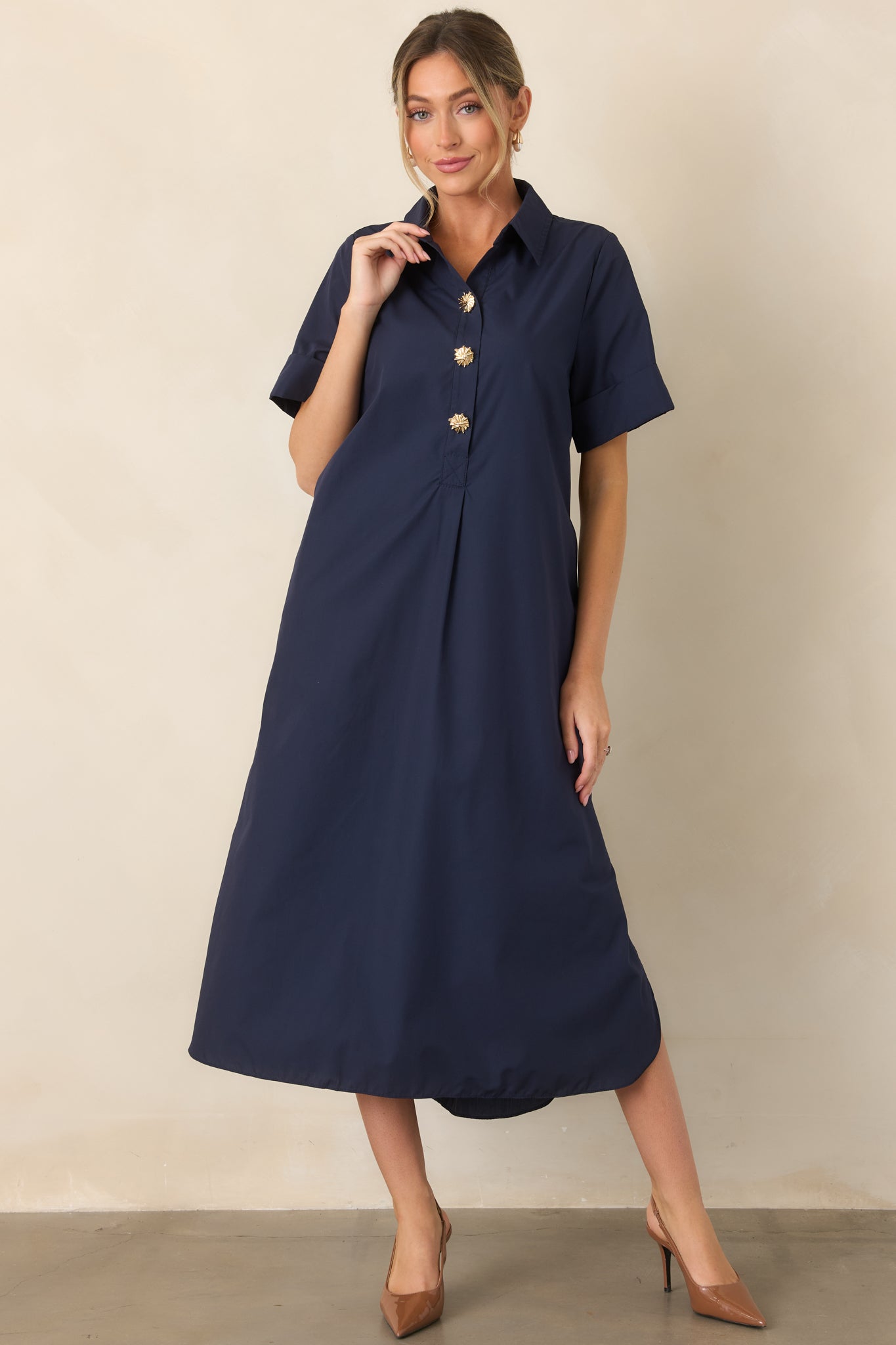 Relaxed navy A-line maxi dress featuring a polished button-front placket and gold floral button accents.