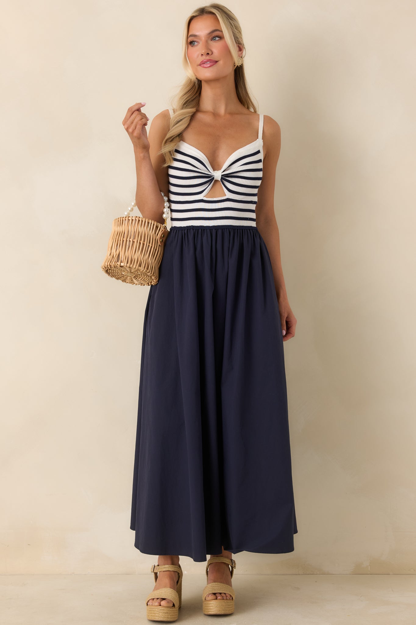 Navy and ivory midi dress with ribbed knit bodice, twist-front detail, and subtle cutout.