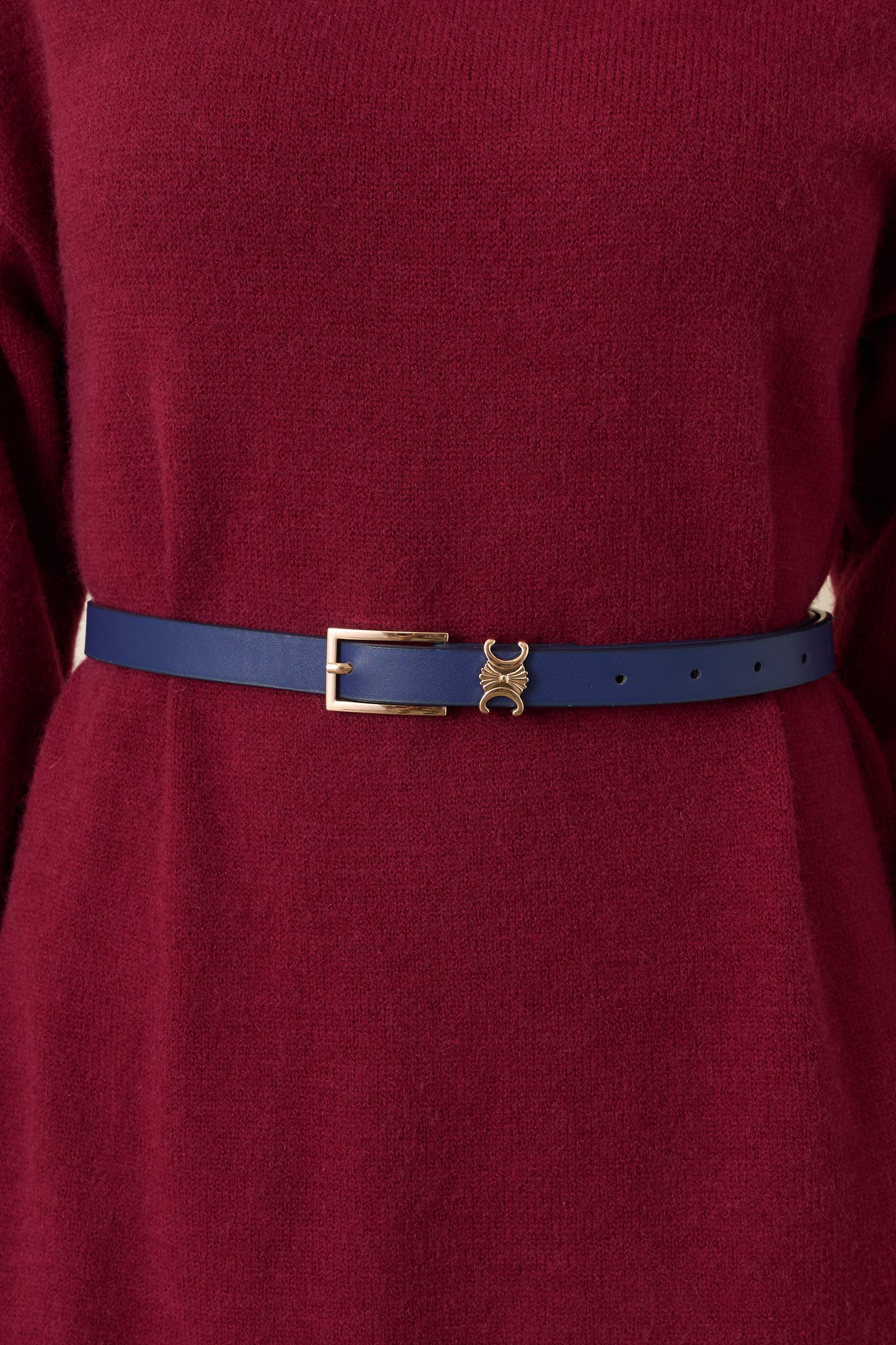 Close-up of the navy belt’s smooth faux leather texture and polished gold-tone buckle.