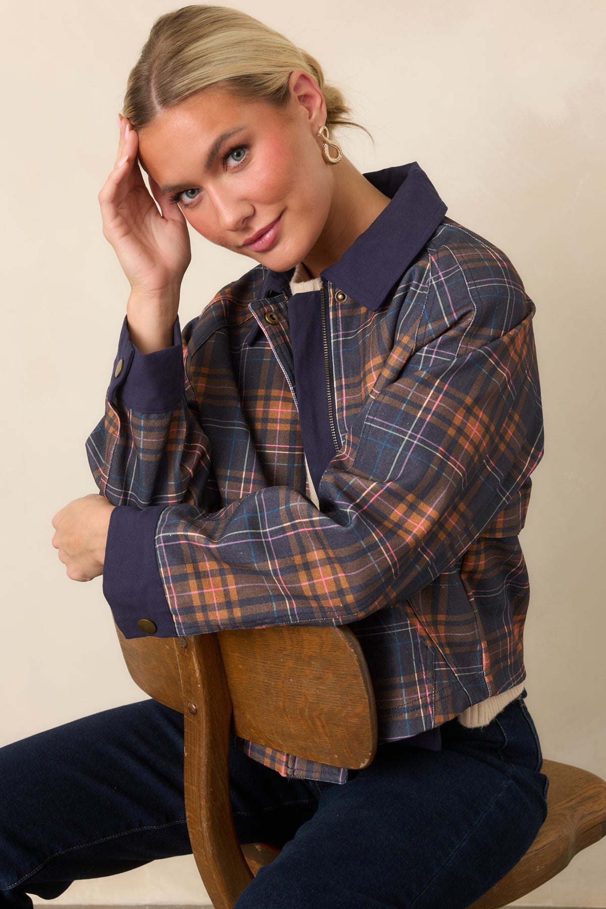 Warm brown, pink, and blue plaid stands out against the navy base and solid navy collar trim.