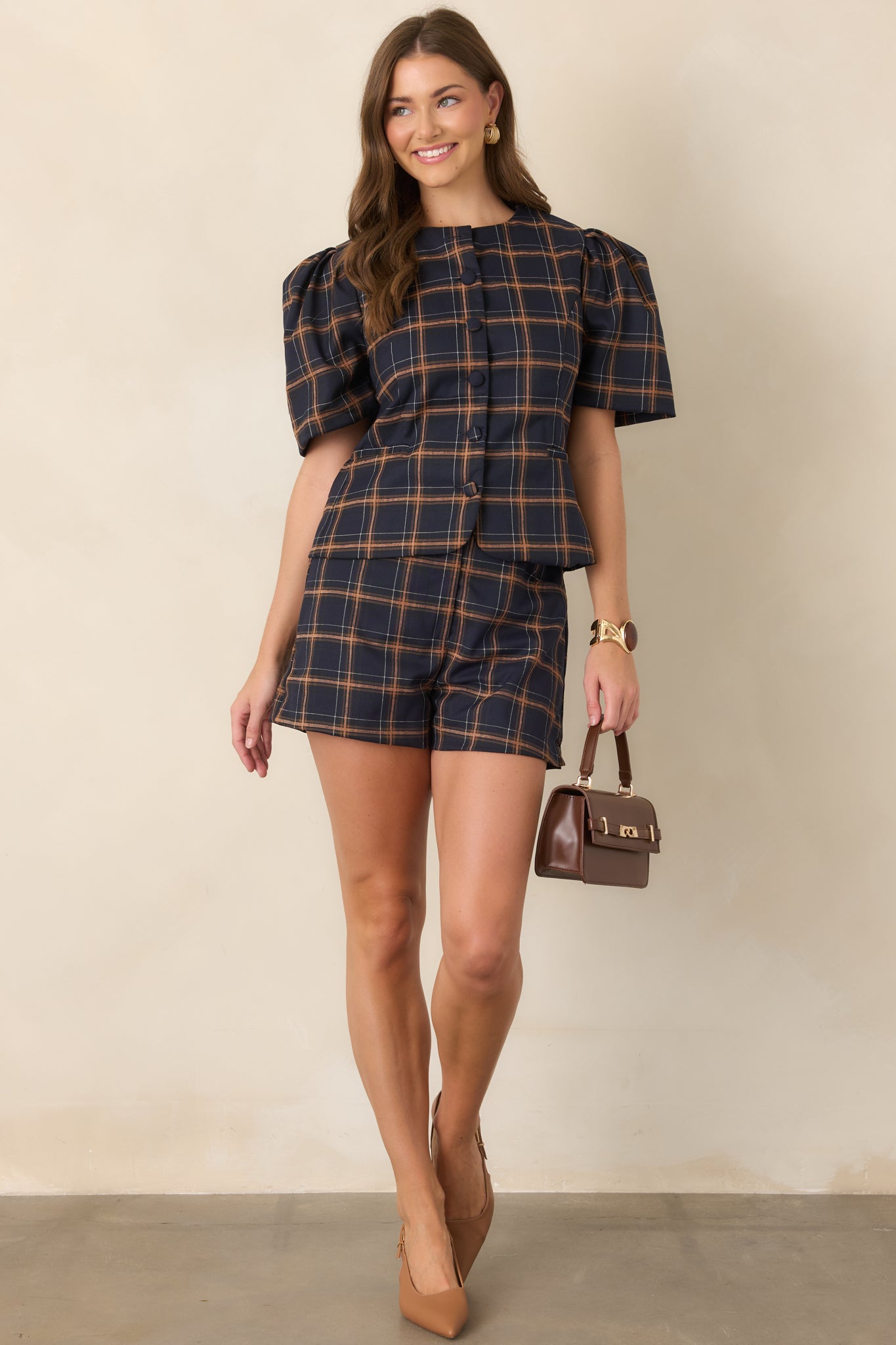 Navy and camel plaid shorts highlighting their structured silhouette, functional front pockets, and polished tailored finish.