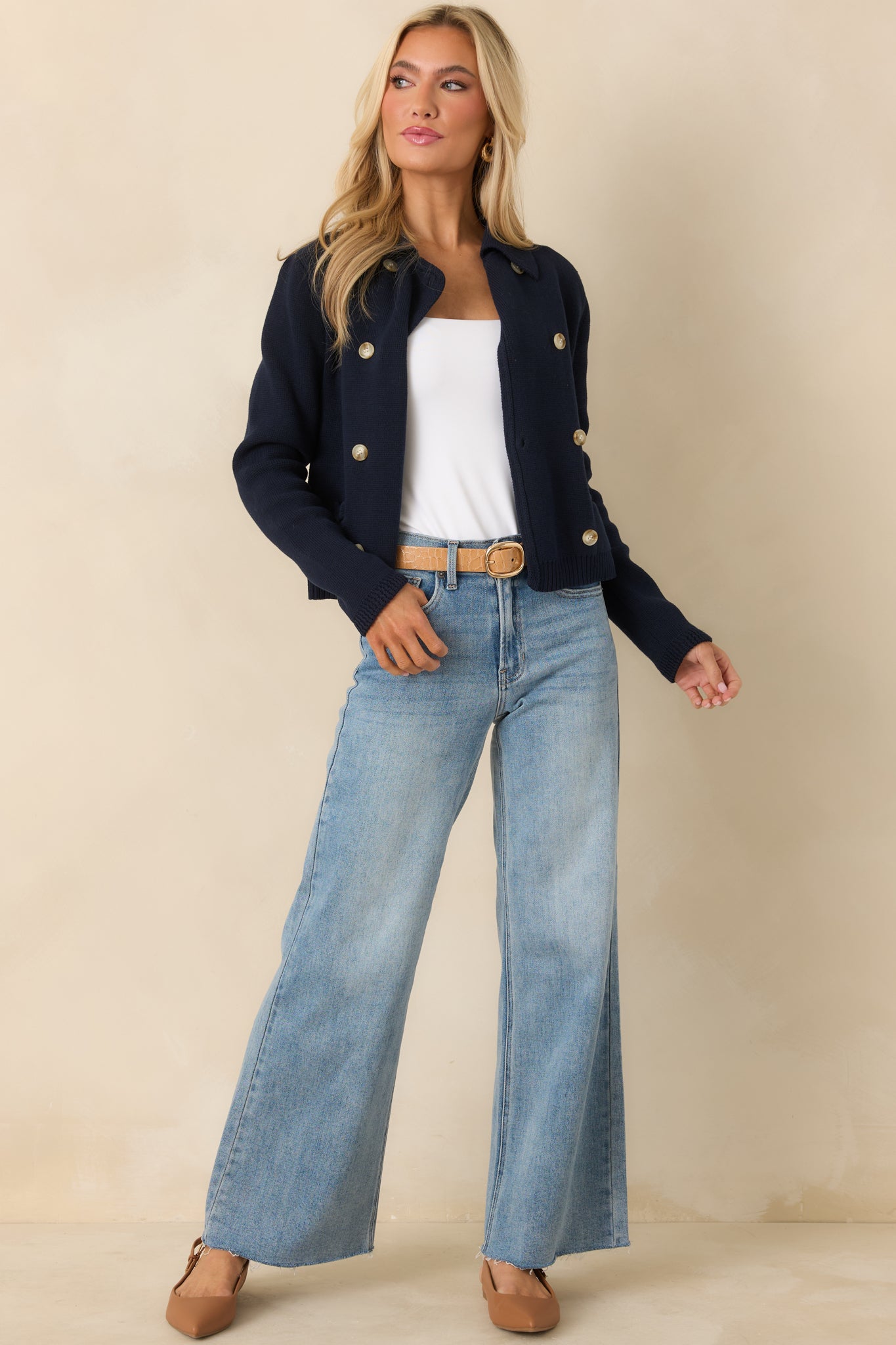 Soft navy cardigan showing the button-front closure, front patch pockets, and ribbed hem in a comfortable layered shape.