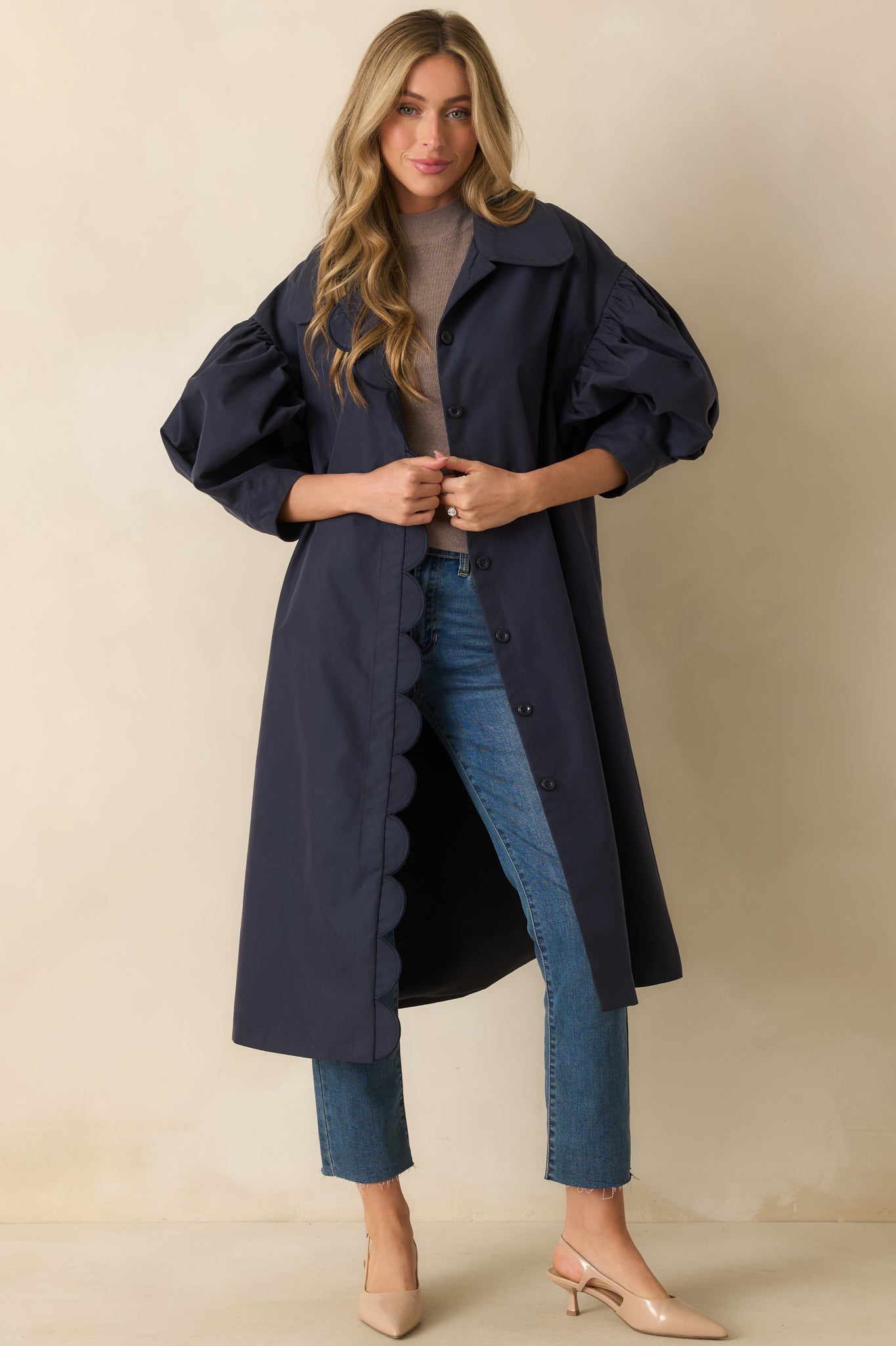 Detail of the collar neckline and functional buttons on the front of the navy coat.