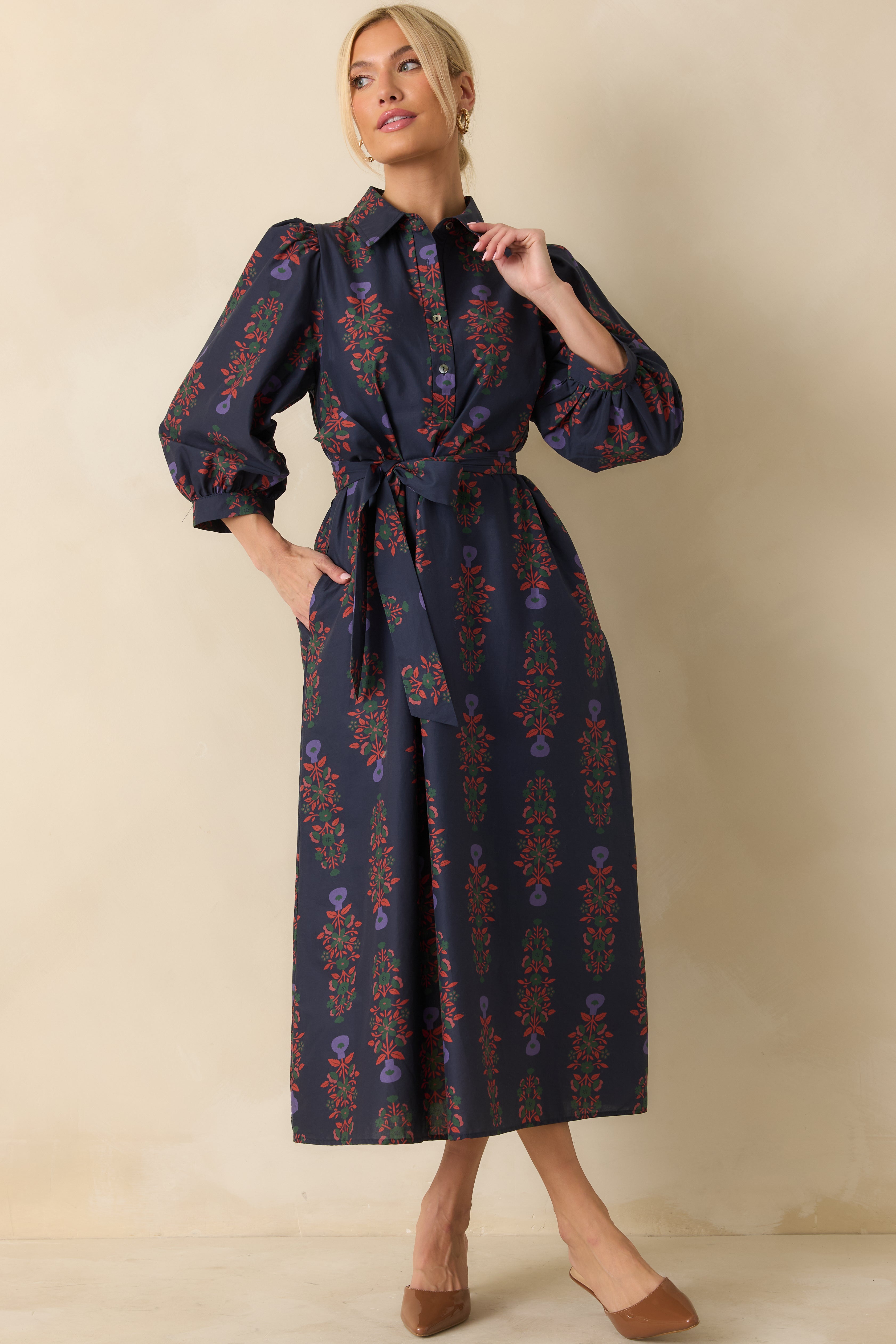 Navy cotton dress with long puff sleeves, button-front closure, and relaxed fit with side pockets.