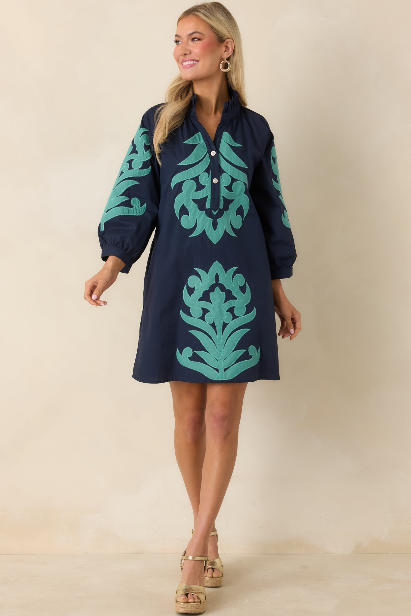 Navy dress with split neckline and refined button accents at the front.