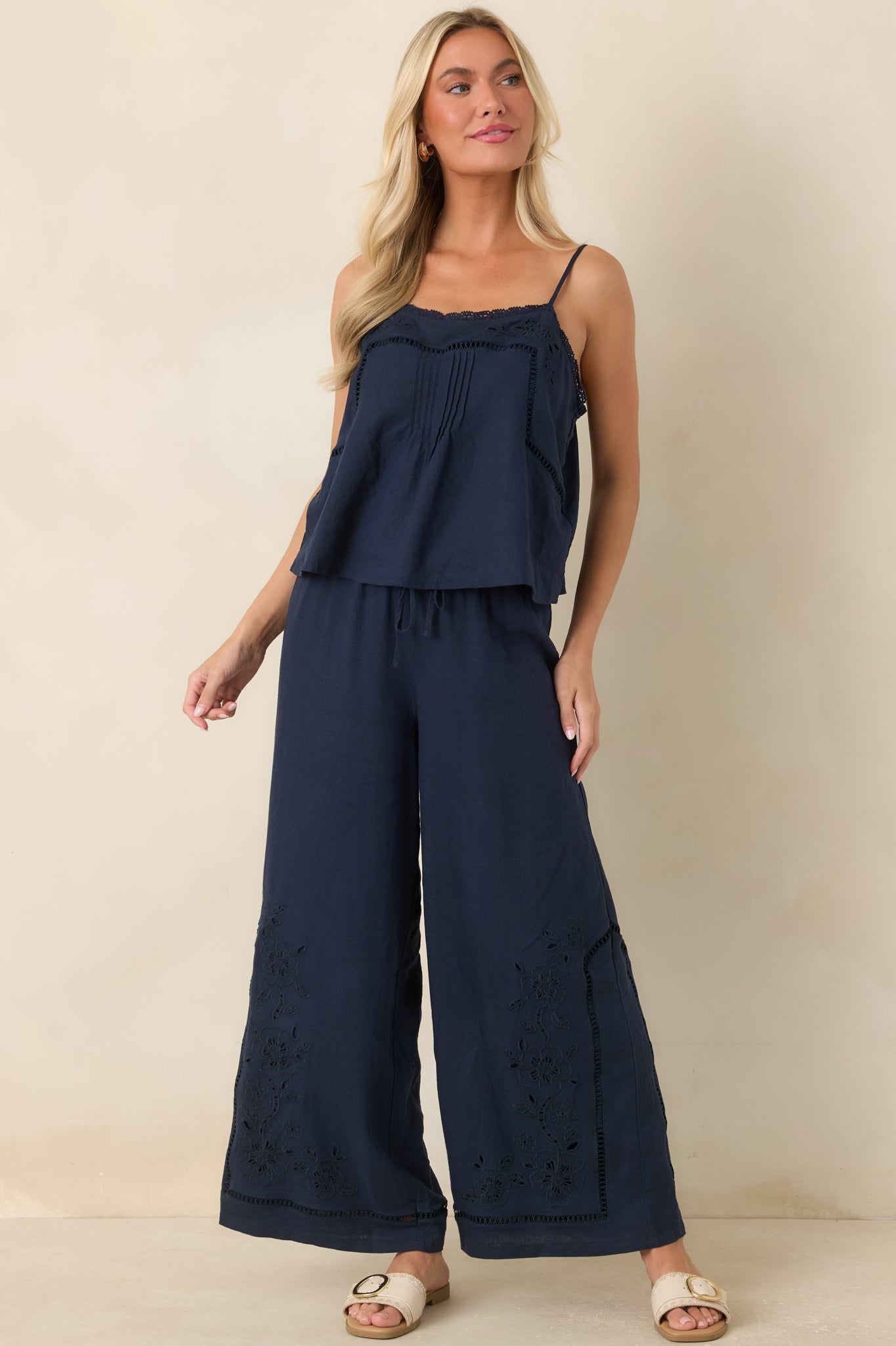 Navy linen blend tank top featuring floral embroidery, a square neckline with lace trim, and adjustable spaghetti straps.