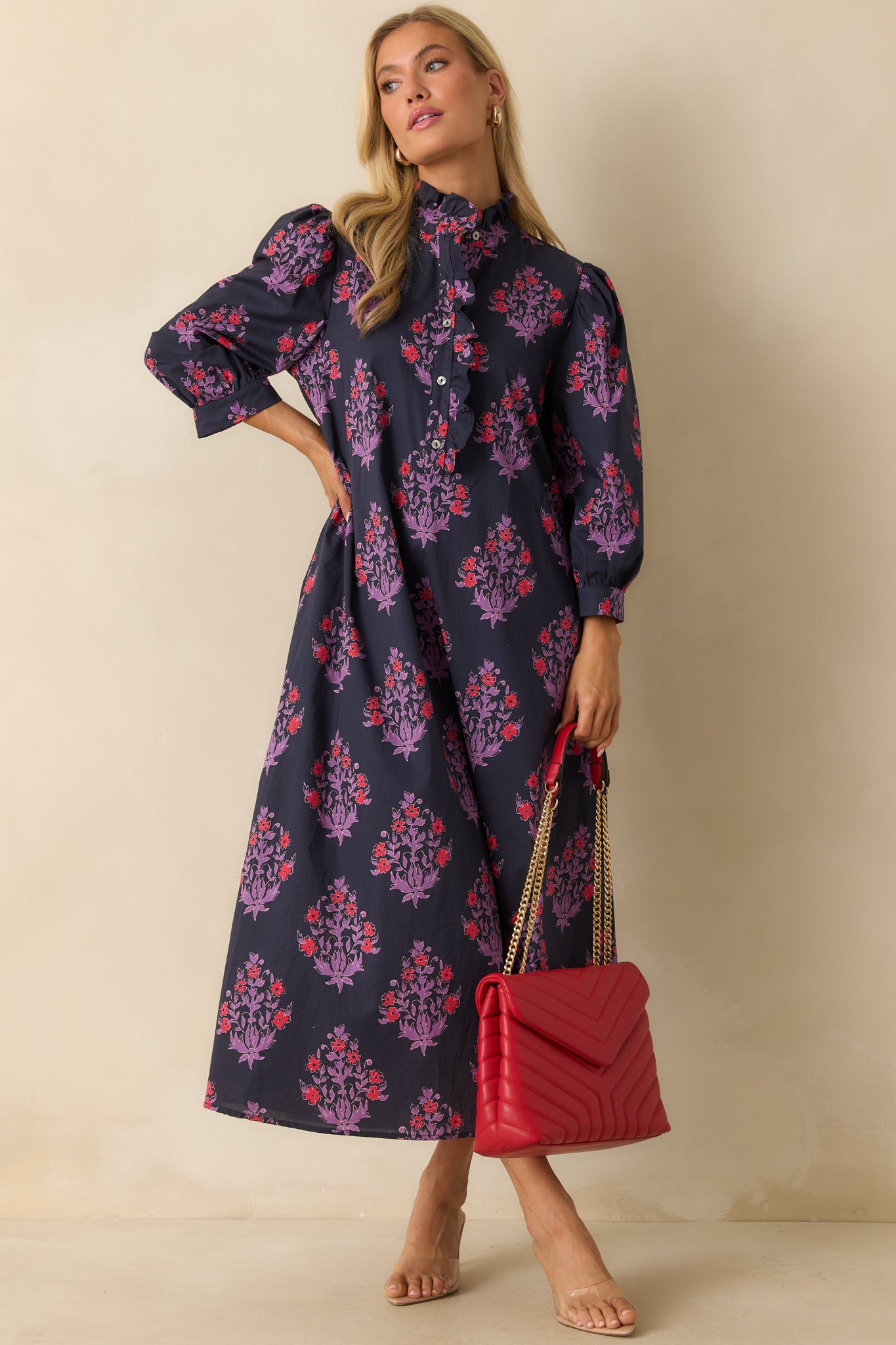 Relaxed-fit navy dress with vibrant floral print, showcasing the high ruffled neckline and full-length design.