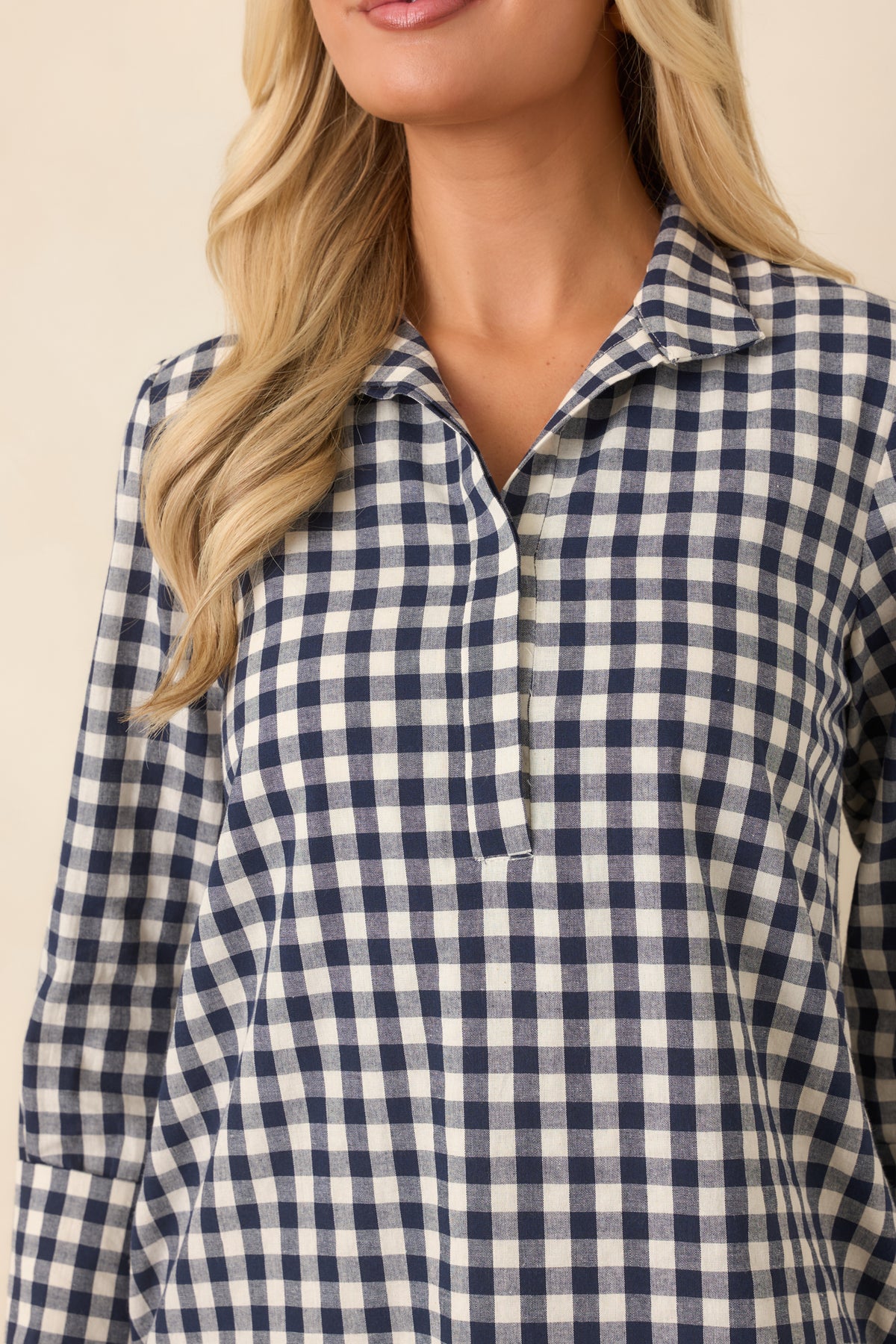 Close-up highlights the navy and ivory gingham weave, structured stand collar, and concealed partial button placket.