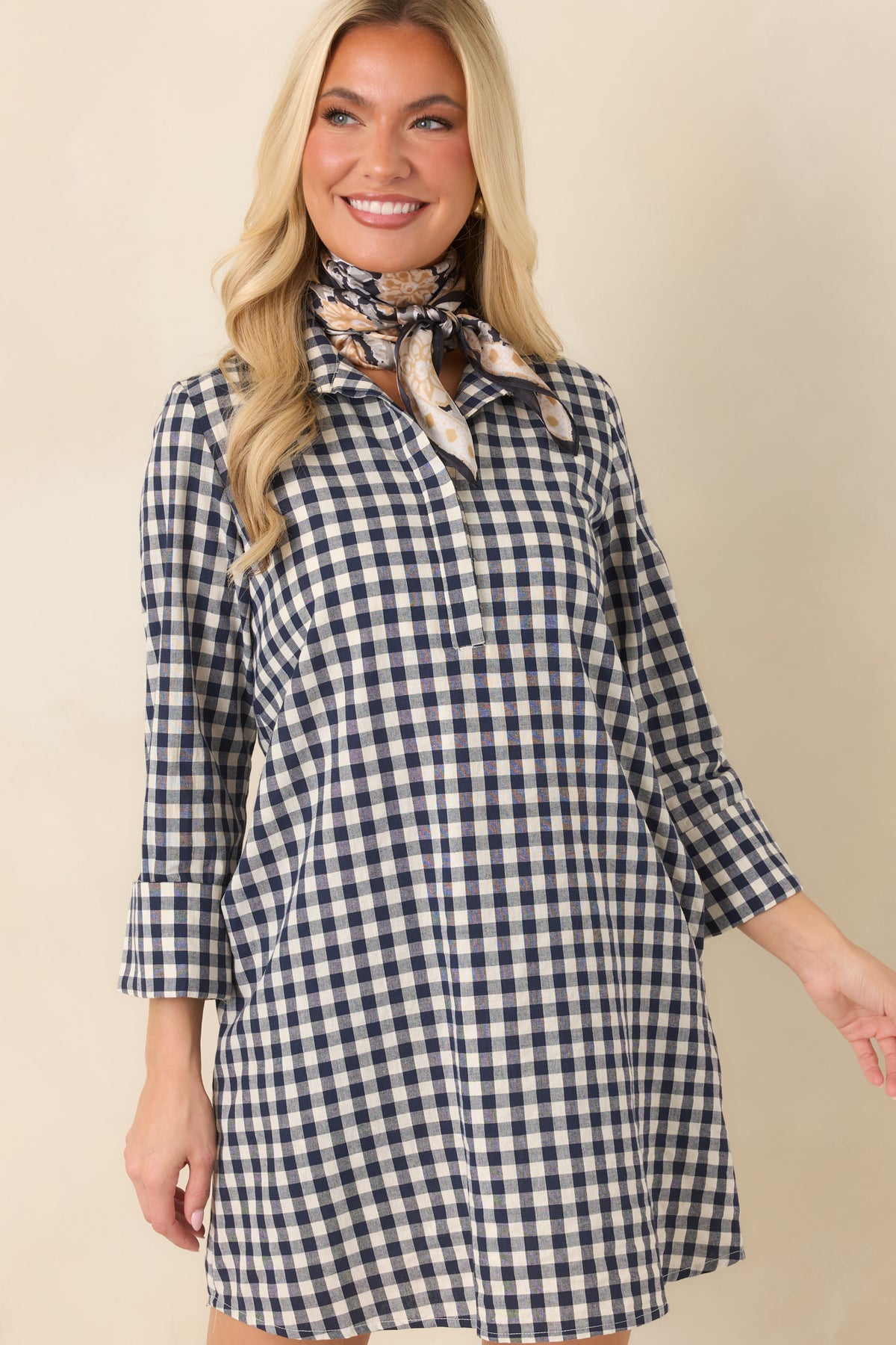 Three-quarter sleeves and a crisp gingham print define the polished design of this mini dress.
