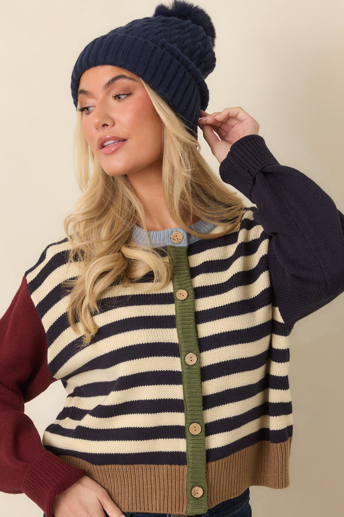 Navy and ivory horizontal stripes cover the cardigan body beneath a light blue crew neckline.