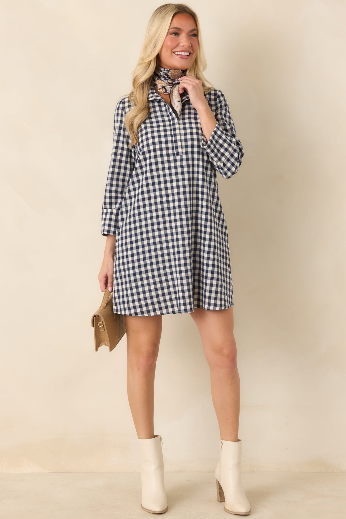 Navy and ivory checkered dress showcases three-quarter sleeves, a clean front design, and convenient side pockets.