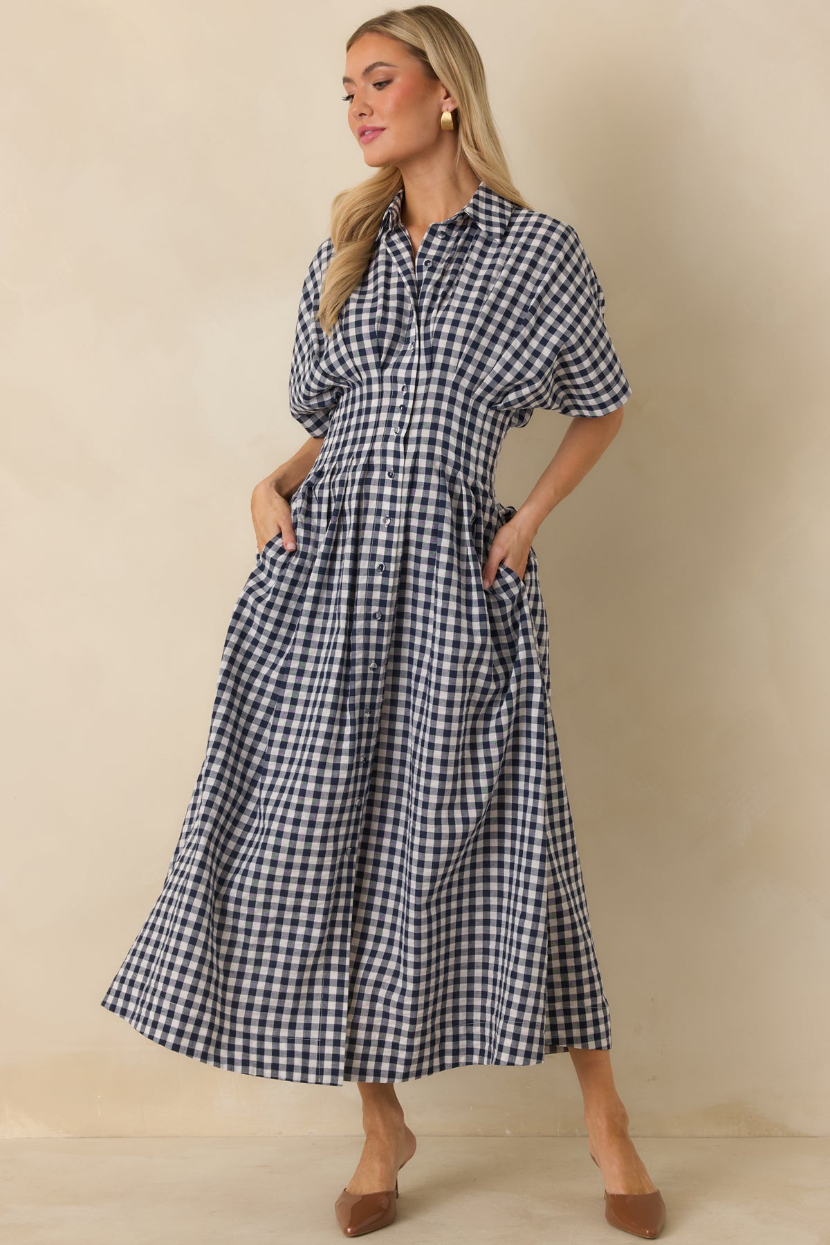 Gingham midi dress featuring short dolman sleeves with turned cuffs, pleated waist detailing, and a relaxed bodice.
