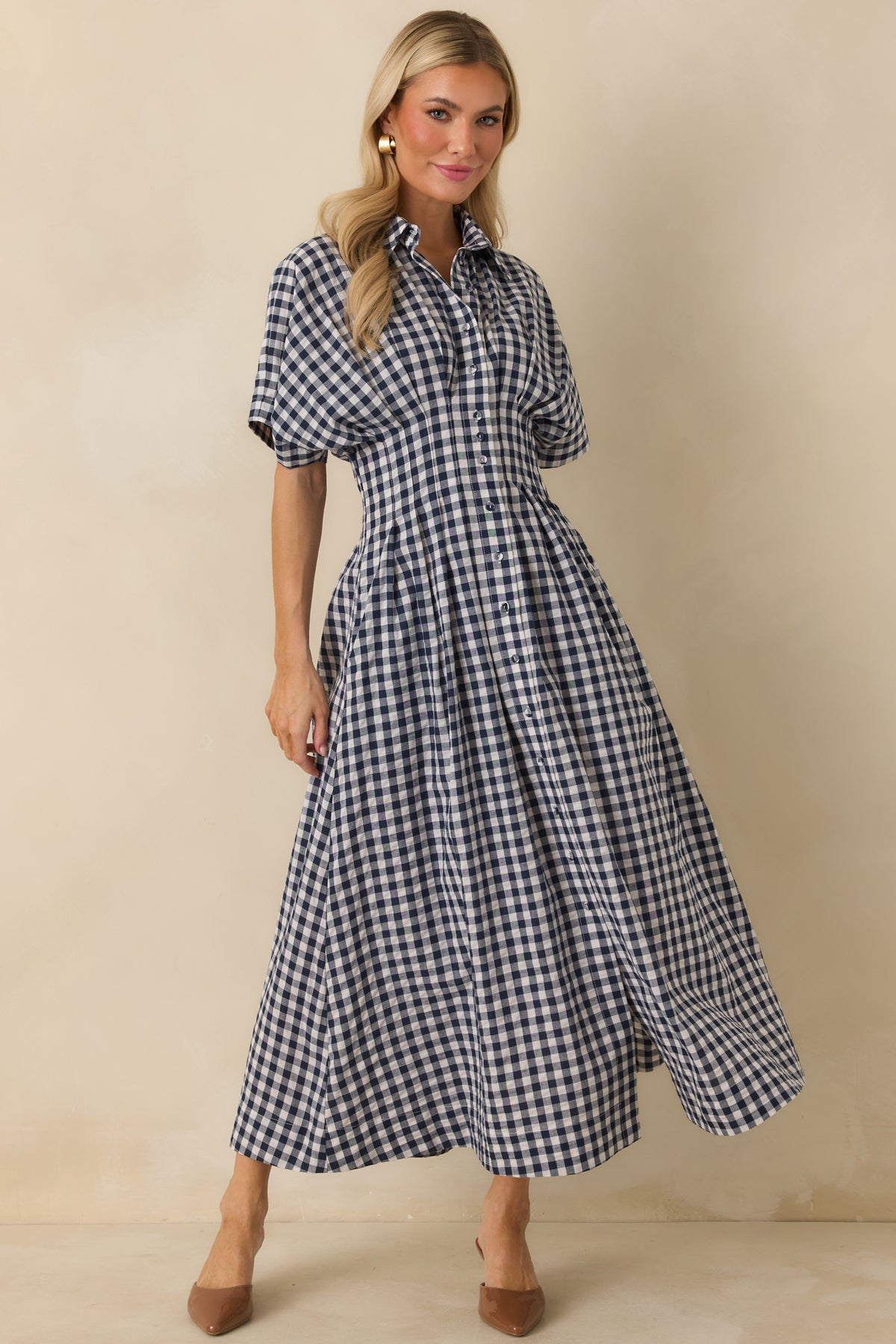 Navy and ivory gingham dress with a defined pleated waist and feminine full midi skirt.

