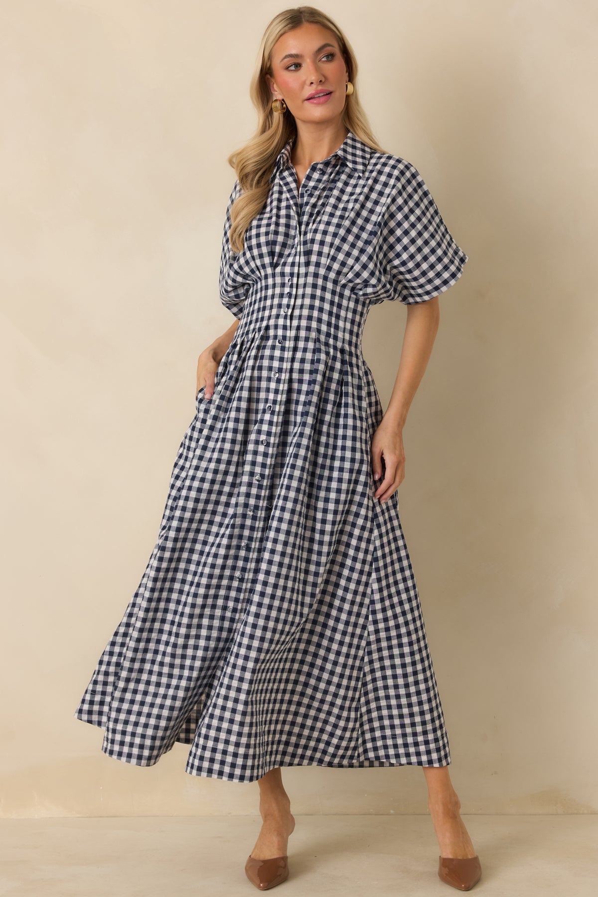 Navy and ivory gingham midi dress with a pointed collar, button front, dolman sleeves, and full flowing skirt.
