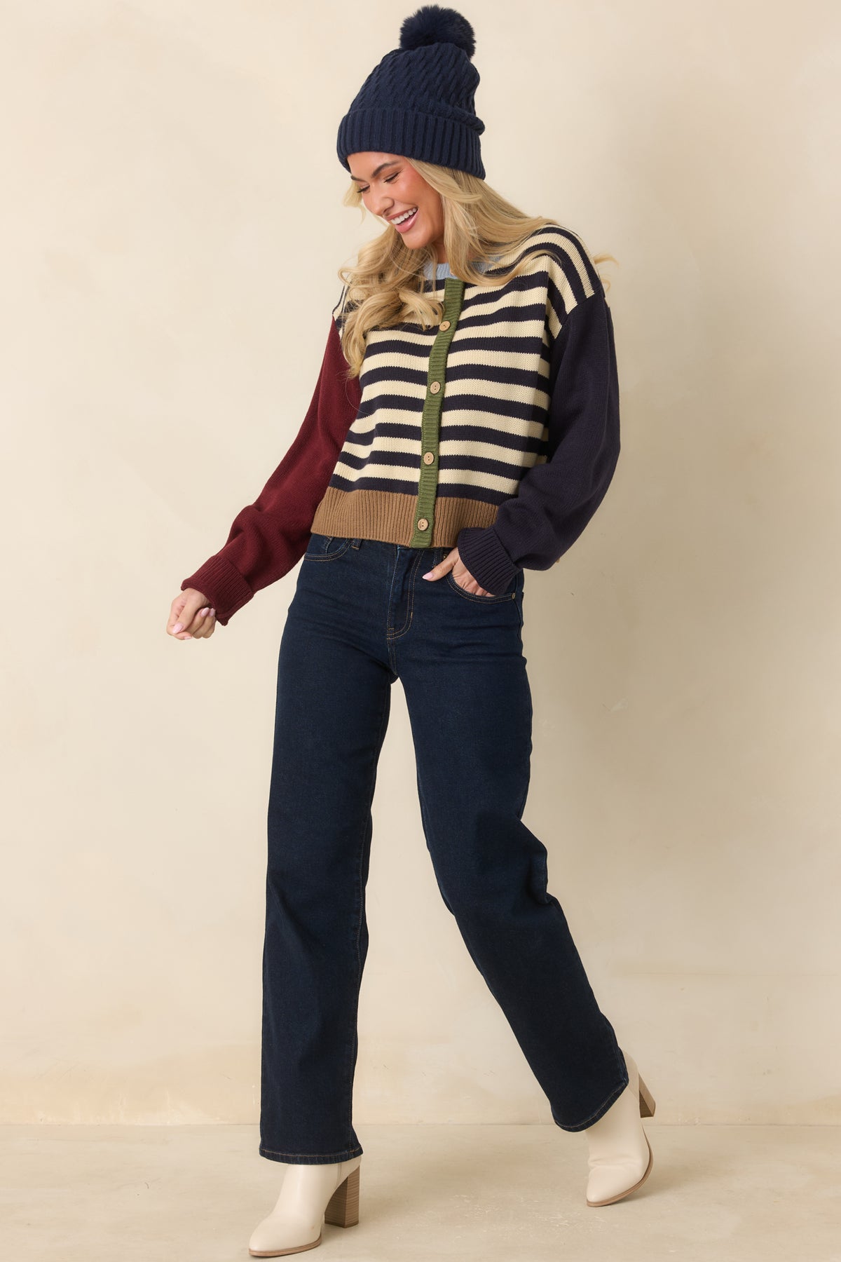 Striped knit cardigan with navy and ivory body panels, contrasting burgundy and navy sleeves, and a camel ribbed hem.