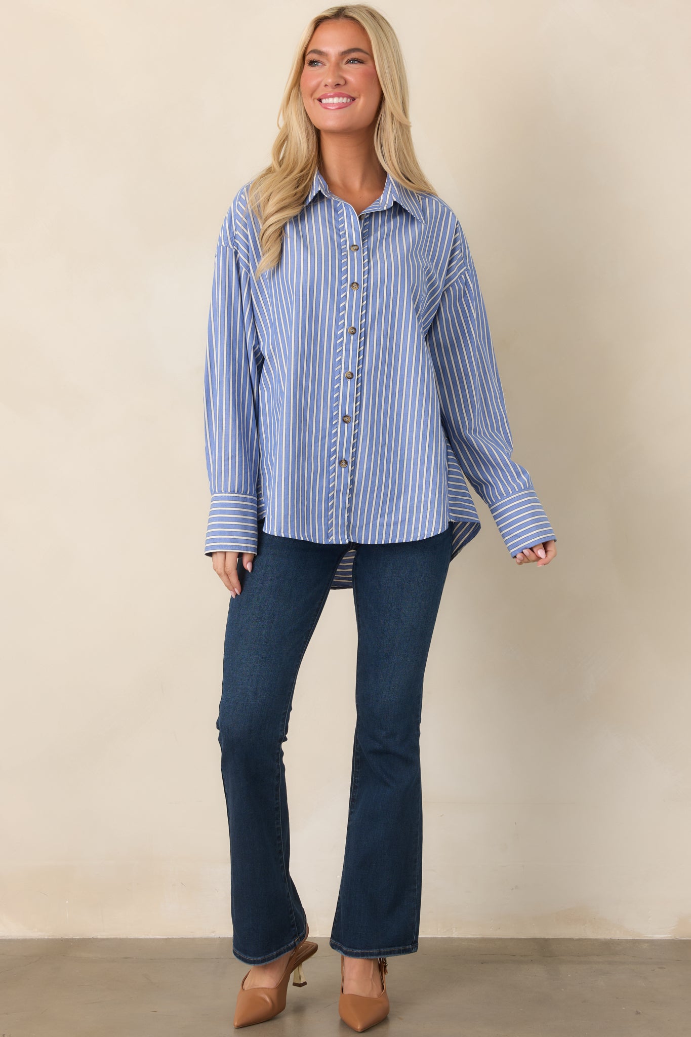 Navy shirt with an ivory stripe pattern, classic collared neckline, functional button-front closure, long sleeves, and scoop hem.