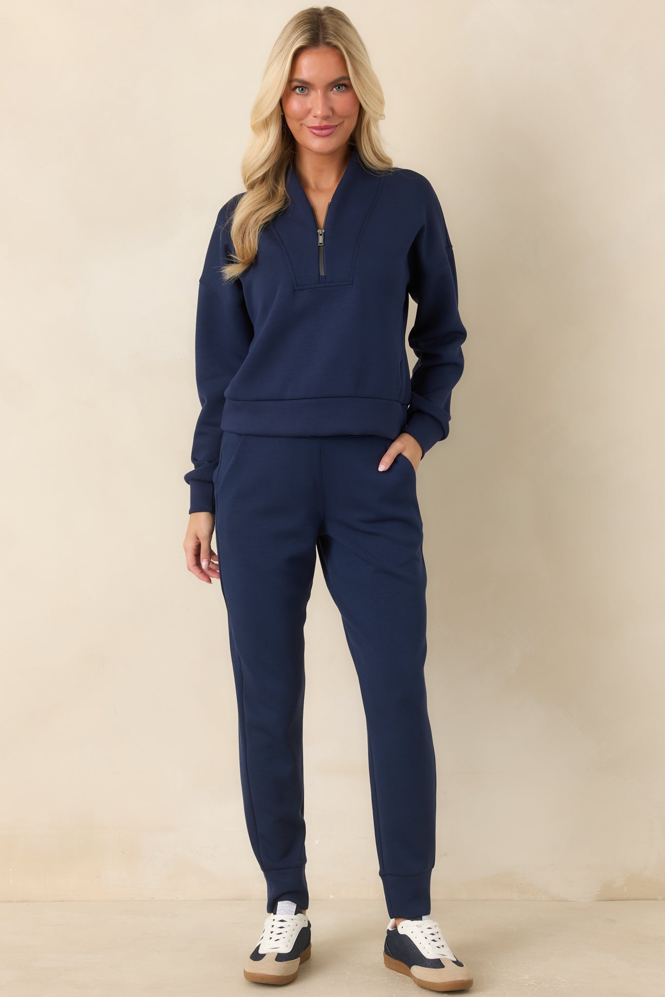 Navy jogger pants showcasing four-way stretch fabric, functional side pockets, relaxed fit, and slim banded cuffs.