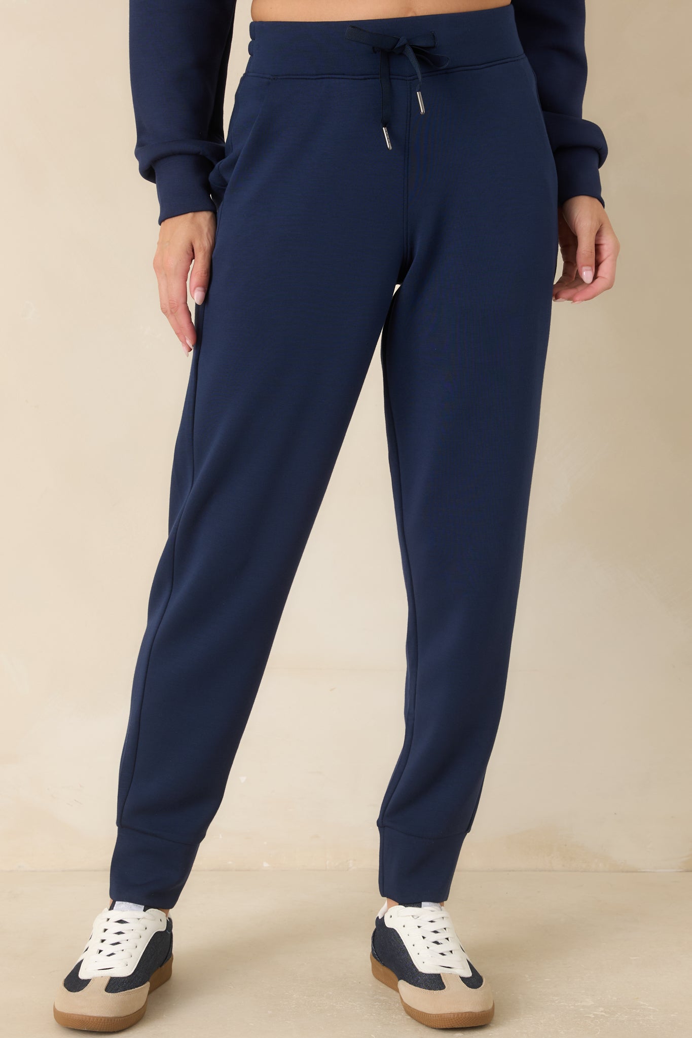 Close view of the navy joggers highlighting the pull-on waistband, adjustable drawstring, and smooth spacer fabric.