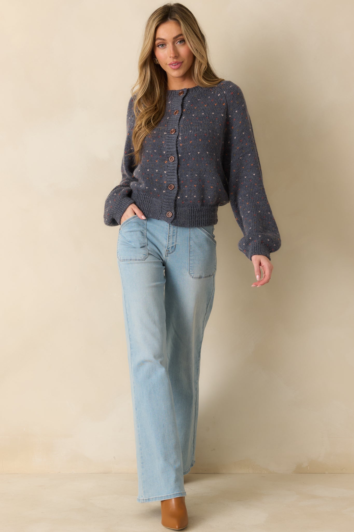 Front-facing navy knit cardigan highlighting ribbed trim along the cuffs, hem, and neckline.