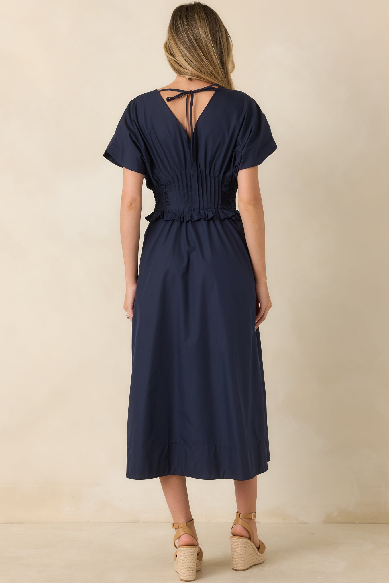 Back view of the navy maxi dress highlighting the smocked waistband and A-line skirt.