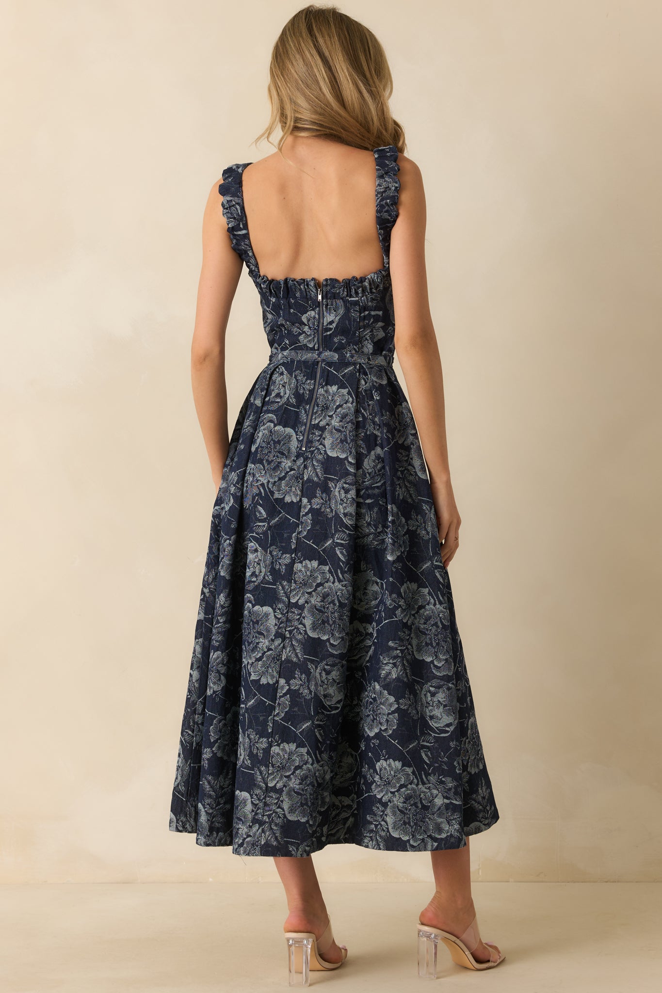 A back view of the navy maxi dress featuring an open back with elastic detail, functional back zipper, and fitted bodice.