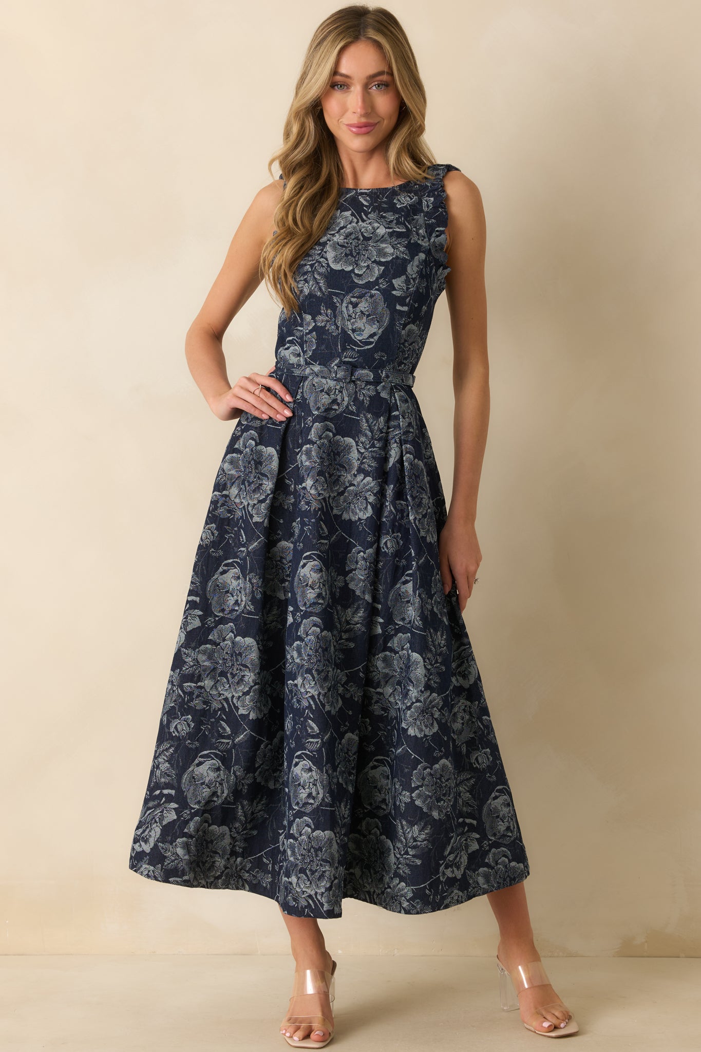 A front view of the navy maxi dress featuring a structured multi-tone denim floral jacquard fabric, high bateau neckline, and fitted bodice.