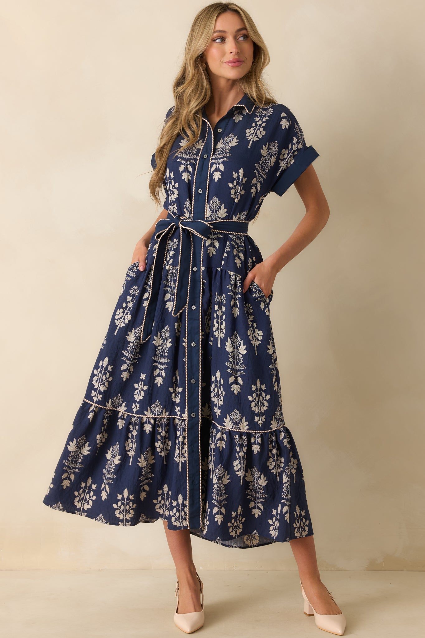 Navy maxi dress with functional pockets, short cuffed sleeves, and a flowing tiered hem.