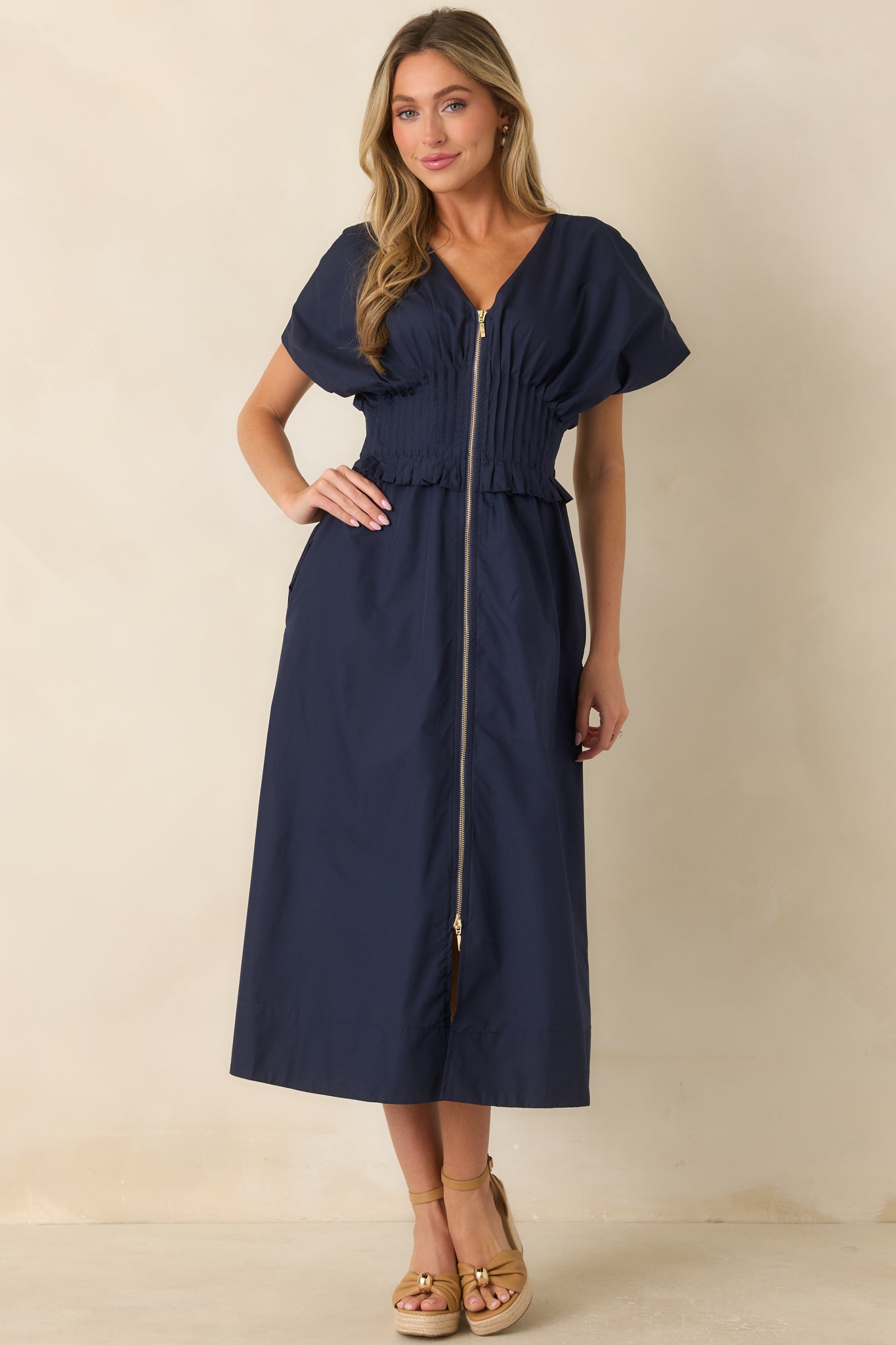 Navy maxi dress showcasing a smocked waistband, ruffled trim, and relaxed flowing silhouette.