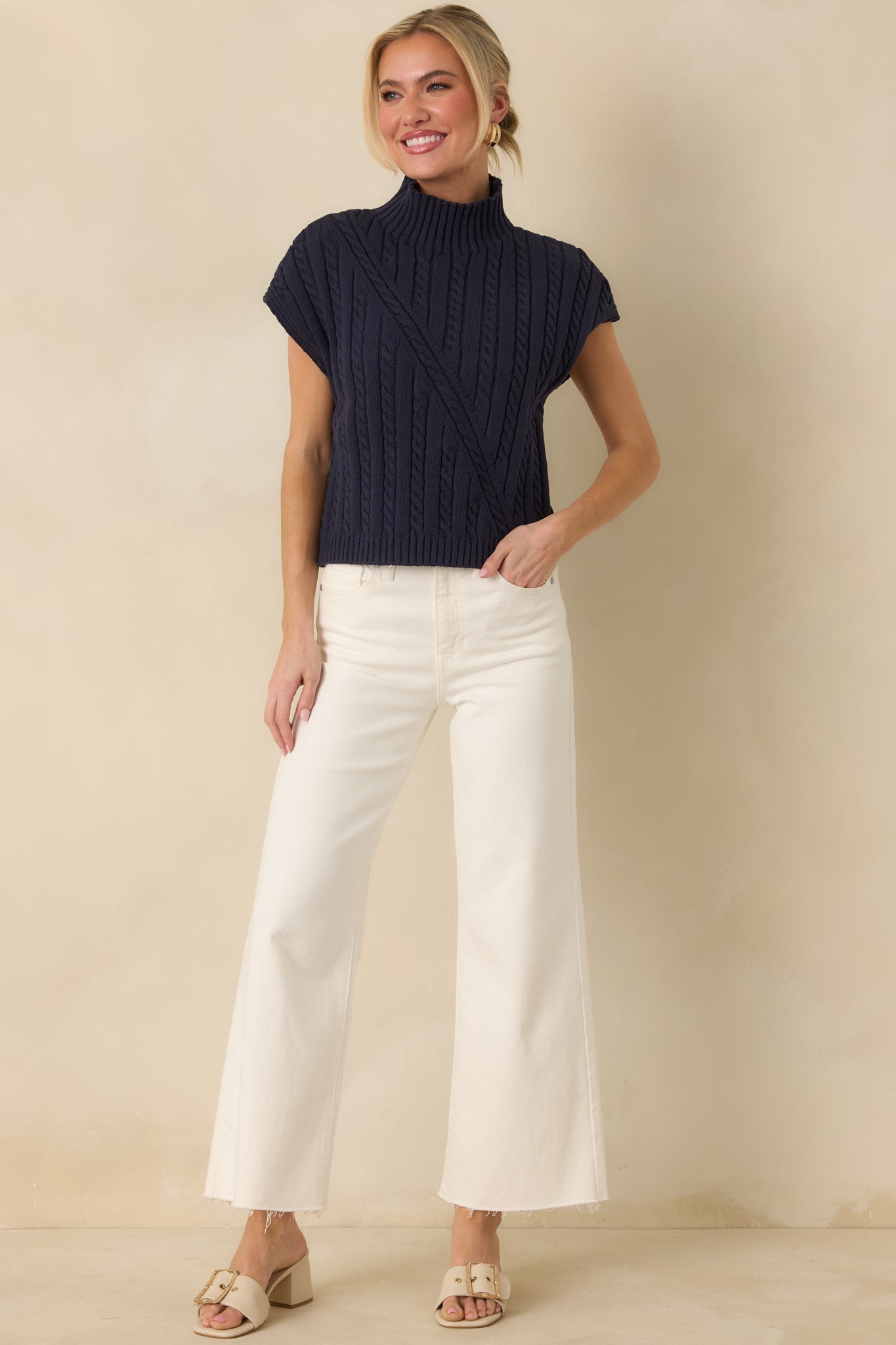 Navy mock neck sweater showcasing textured cable stitching and a straight, relaxed fit through the body.