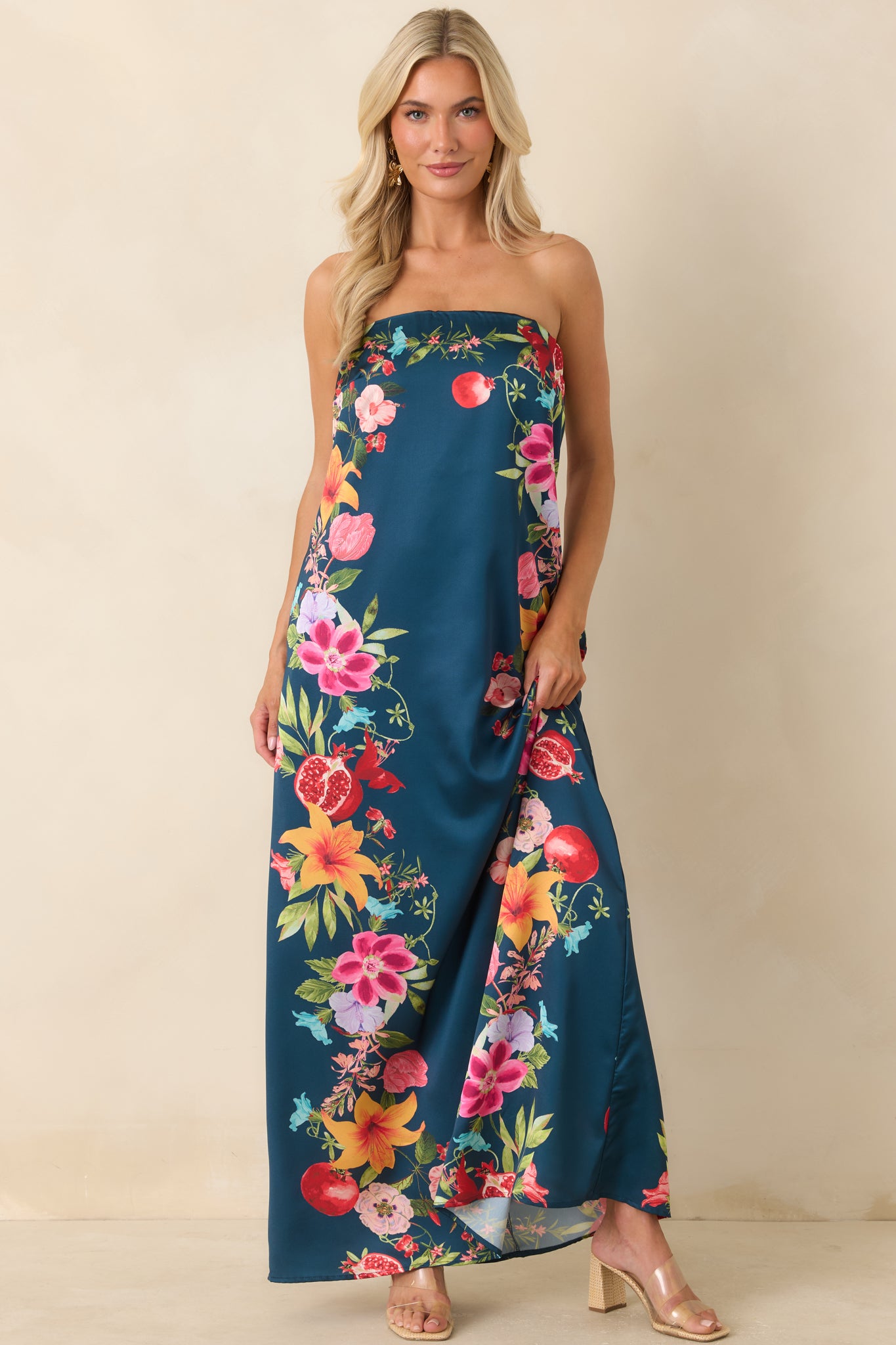 Navy multi floral maxi dress showcasing a vibrant botanical and fruit-inspired print, strapless design, and elegant floor-length shape.