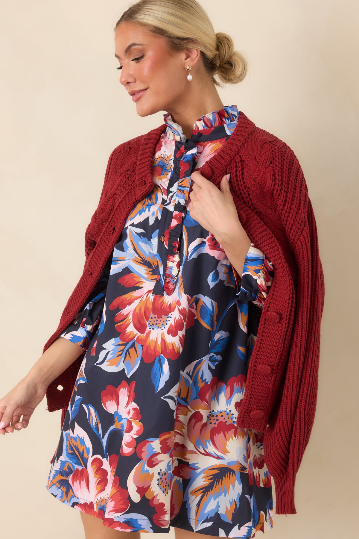 Navy multicolor floral mini dress featuring a ruffled high collar, decorative front placket, and loose-fitting silhouette.