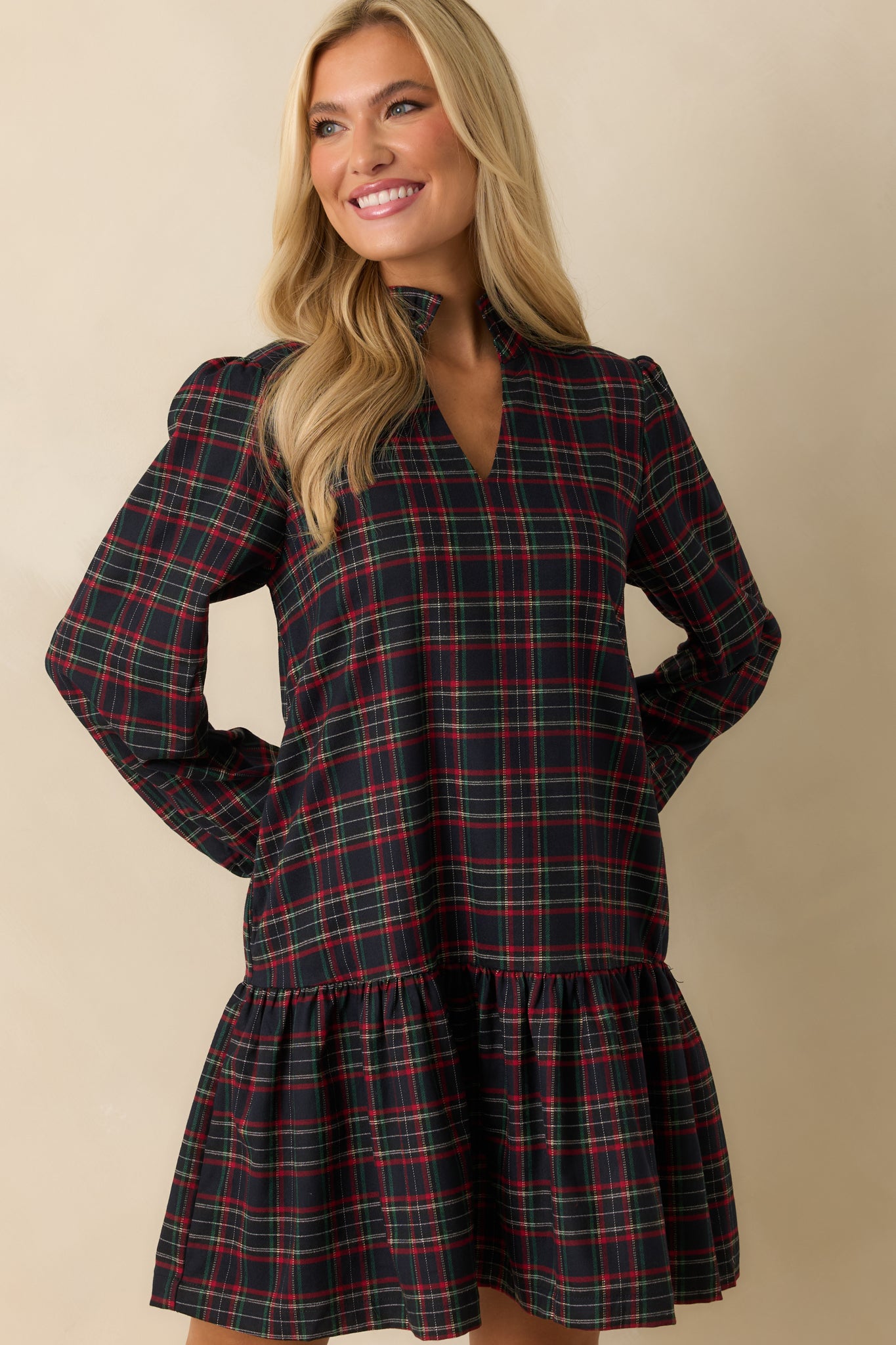 Navy plaid mini dress cropped mid-torso, showing tiered ruffle hem and long sleeves.