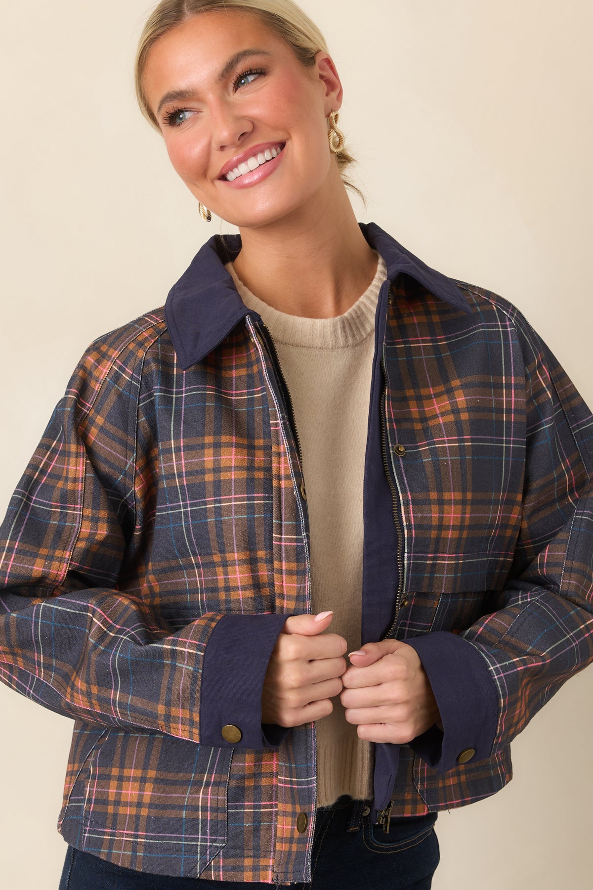 Raglan sleeves and solid navy cuffs add definition to the colorful plaid jacket.