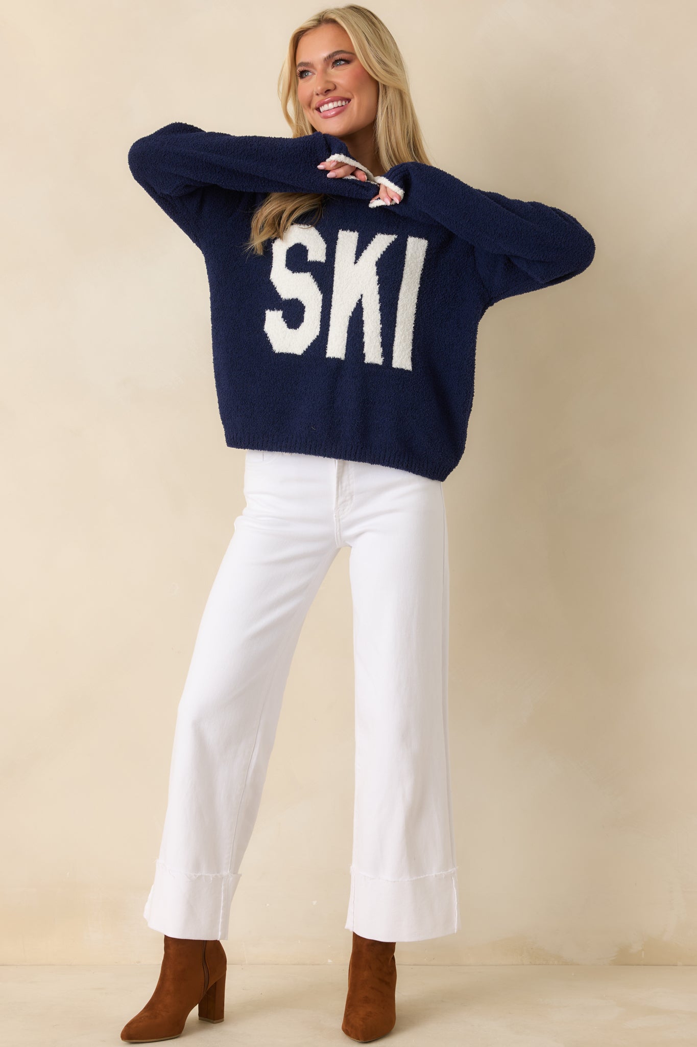 Navy plush-knit sweater showing bold white “SKI” lettering across the front.