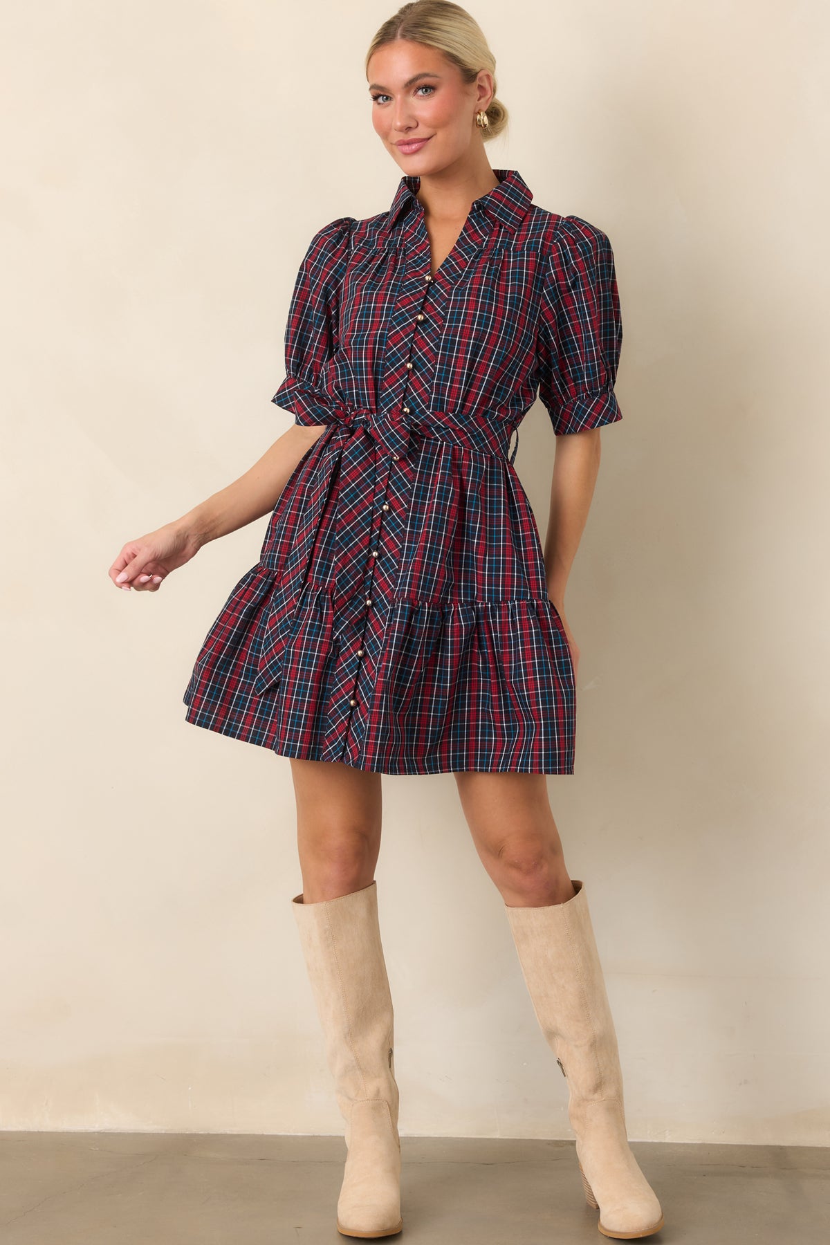 Navy and red plaid shirt dress with a collared neckline, puff sleeves, gold-tone buttons, matching waist belt, and tiered mini skirt.