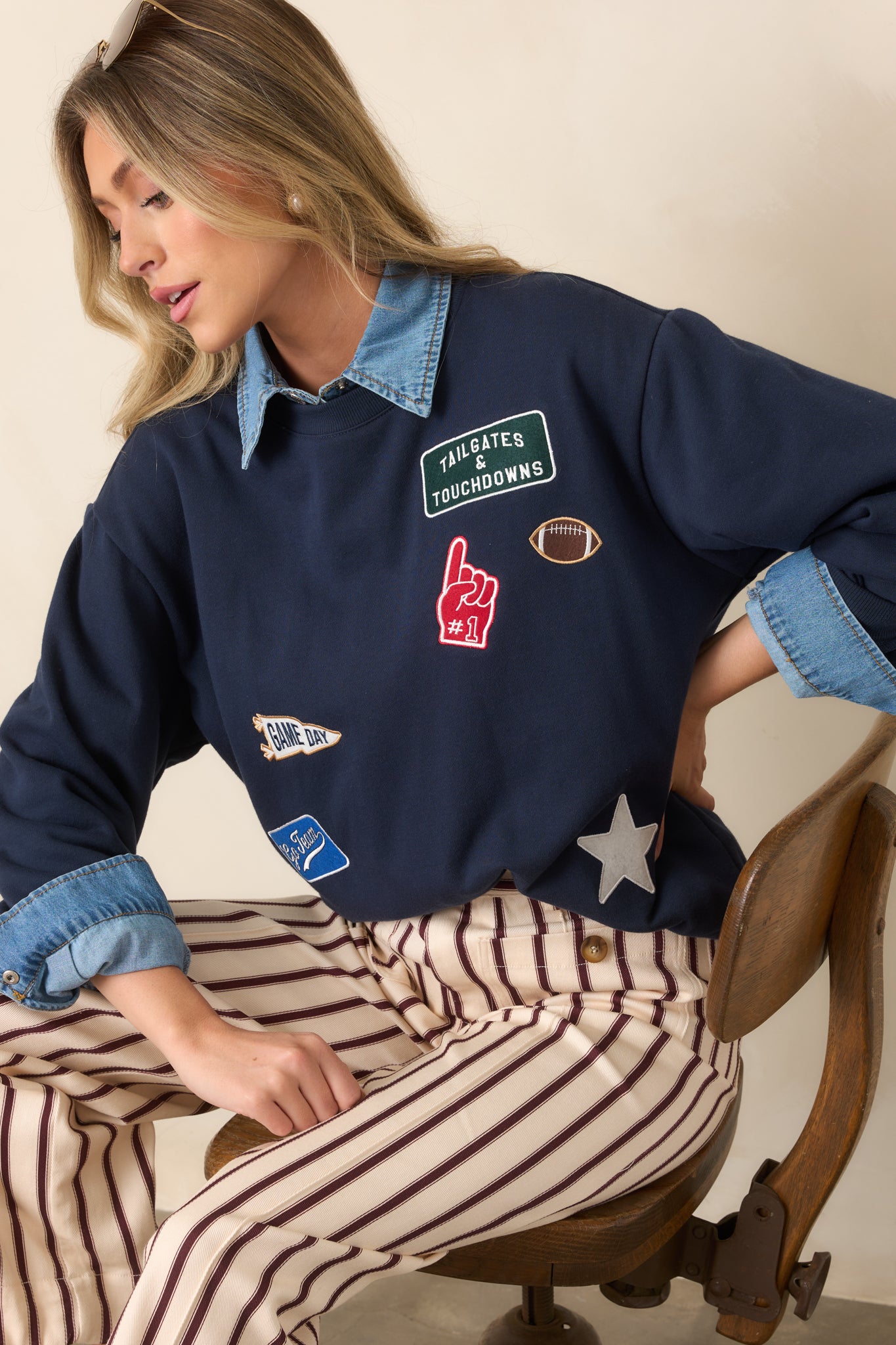 Relaxed navy sweatshirt featuring a classic crew neck, oversized dropped shoulders, ribbed cuffs and hem, and football-inspired embroidered details.