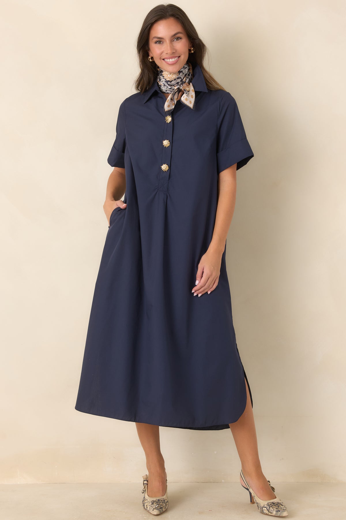 Navy shirt dress featuring a partial button-front placket with statement gold floral buttons and side pockets.