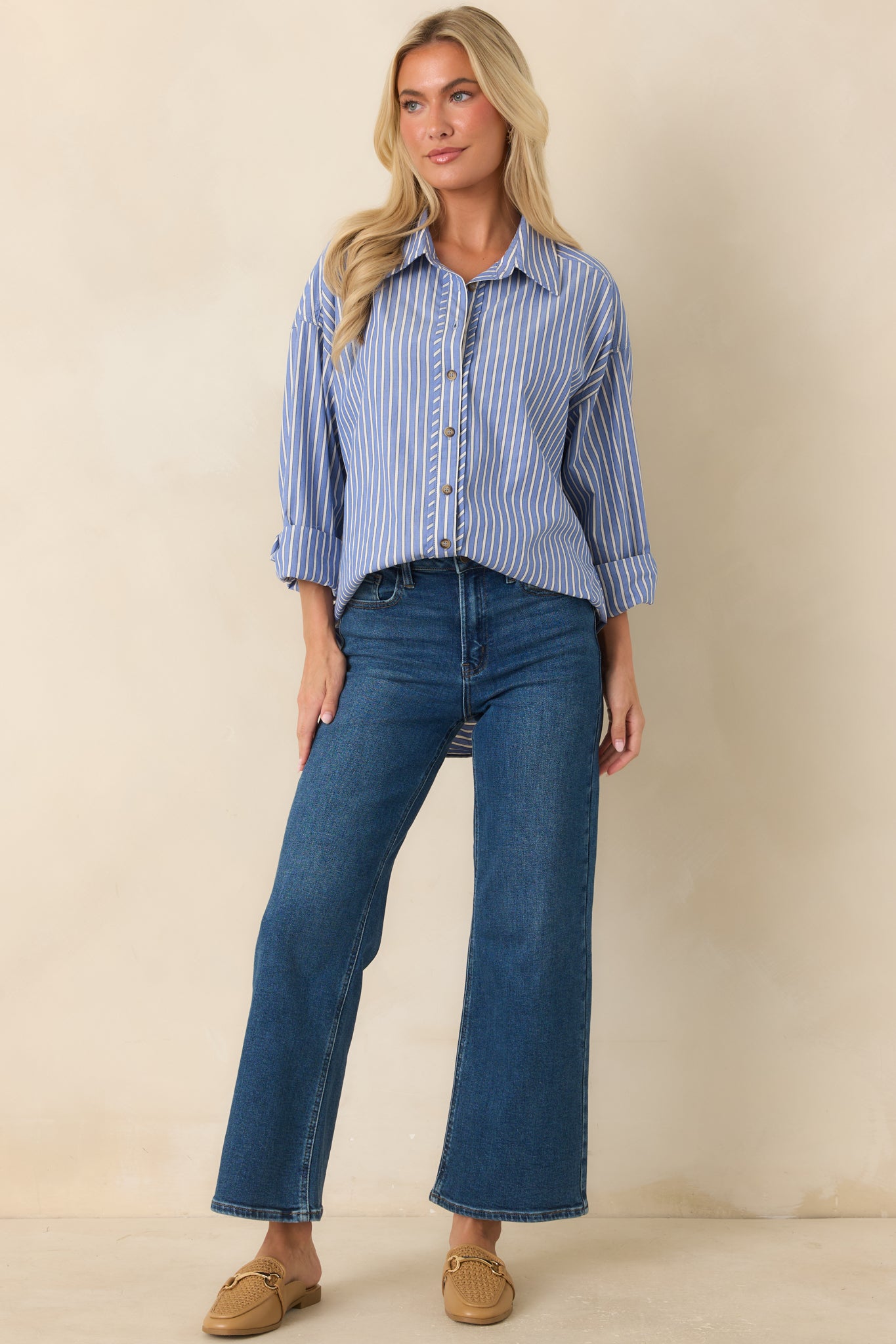 Navy stripe button-up shirt featuring an ivory stripe pattern, collared neckline, long sleeves, and relaxed fit with a scoop hem.